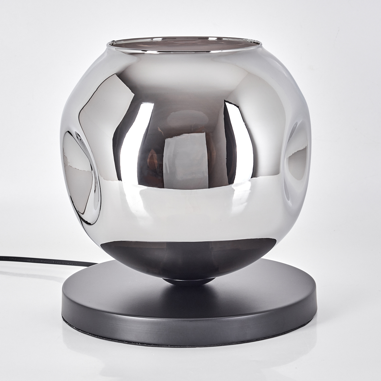 Eine kugelförmige Lampe mit Chromoberfläche auf einem schwarzen Sockel.