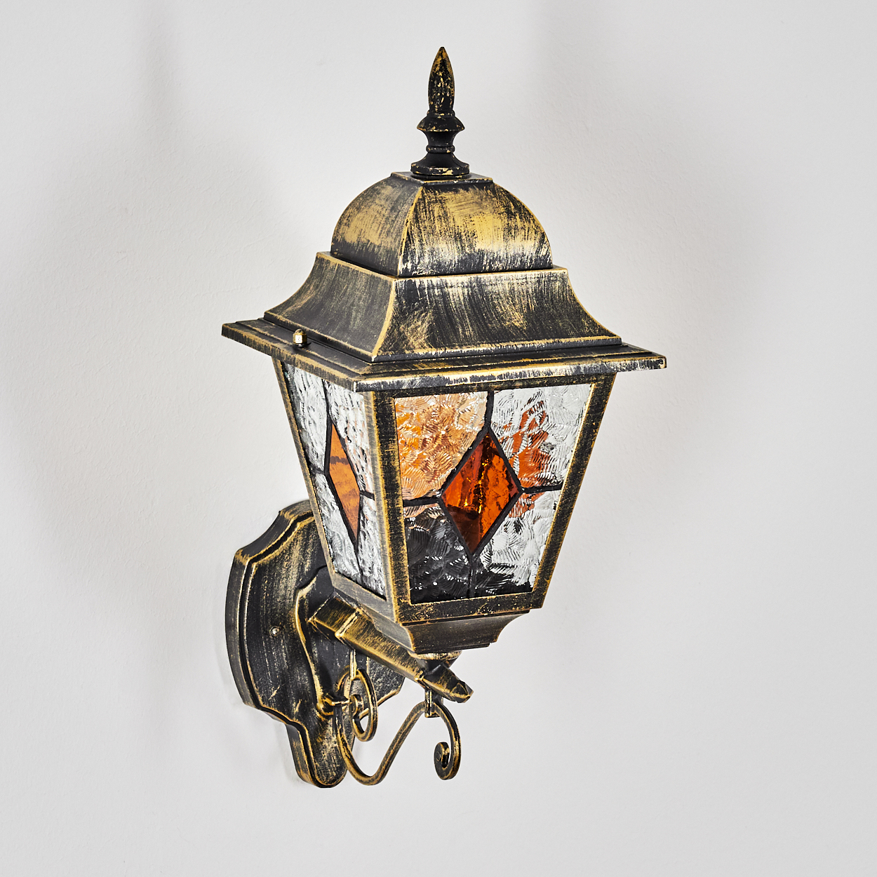 Eine antike Wandleuchte mit gold- und schwarz-metallic-Finish und Glaspaneelen.
