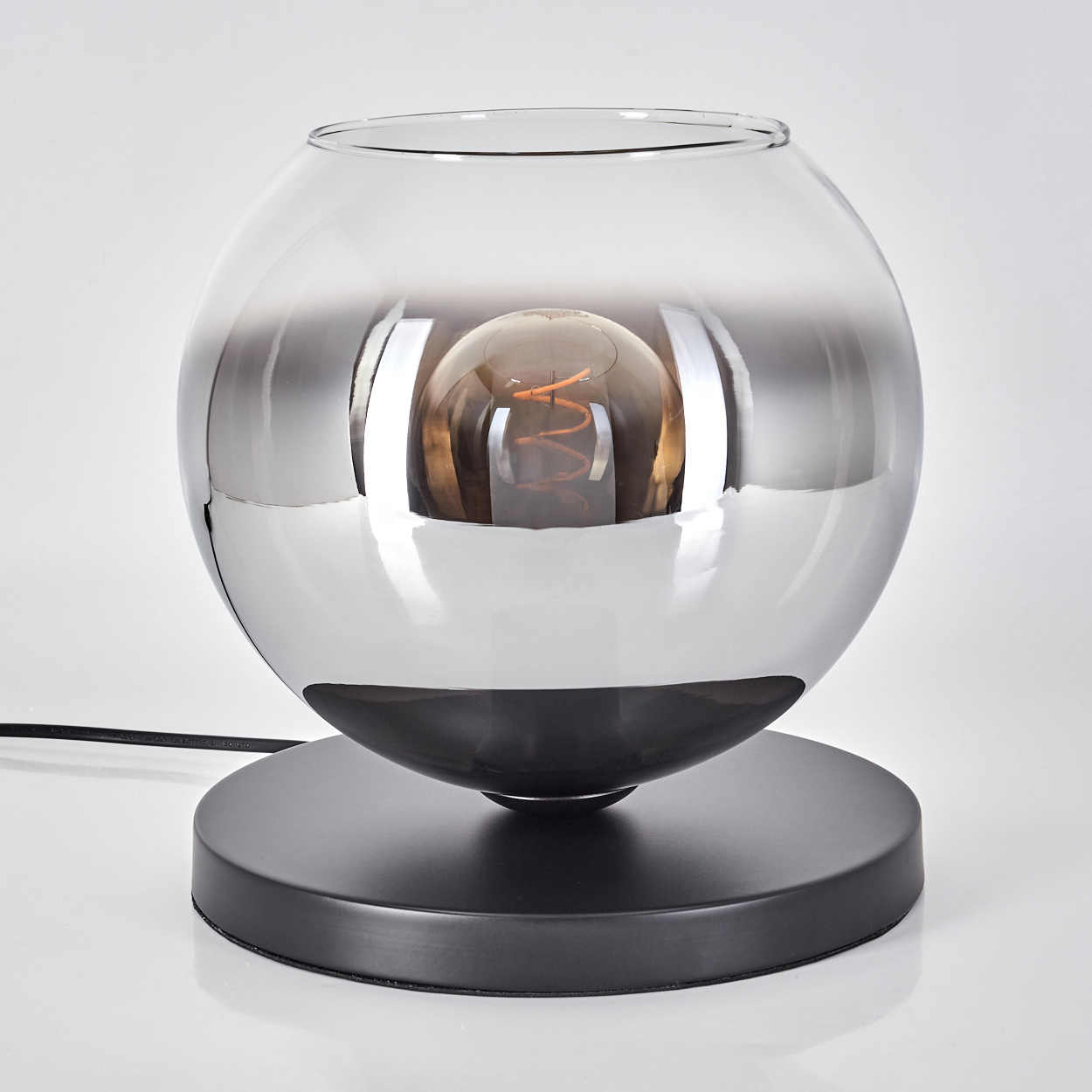 Eine kugelförmige Lampe mit einem versilberten Glasschirm und einer Glühbirne.