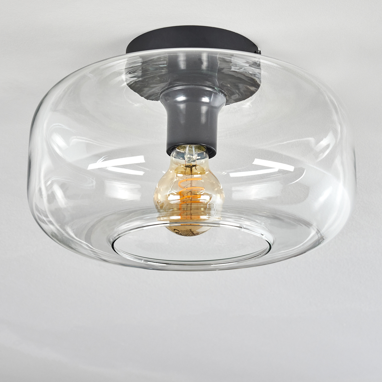 Moderne Deckenleuchte mit klarer Glasglocke und sichtbarer Edison-Glühbirne.