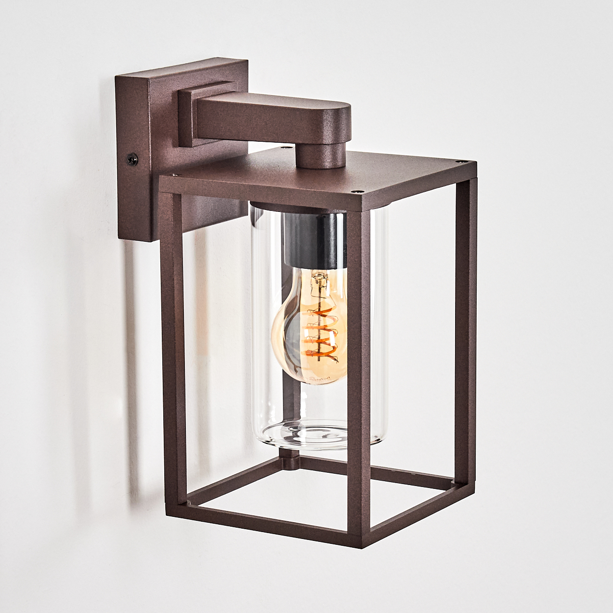 Eine braune Wandleuchte mit Glaszylinder und Glühbirne.