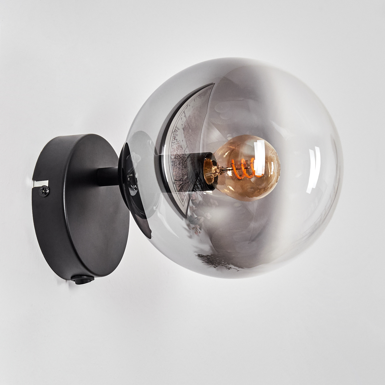 Ein schwarzer Wandspot mit klarem Globus-Schirm, Edison-Birne und Kartenmotiv.