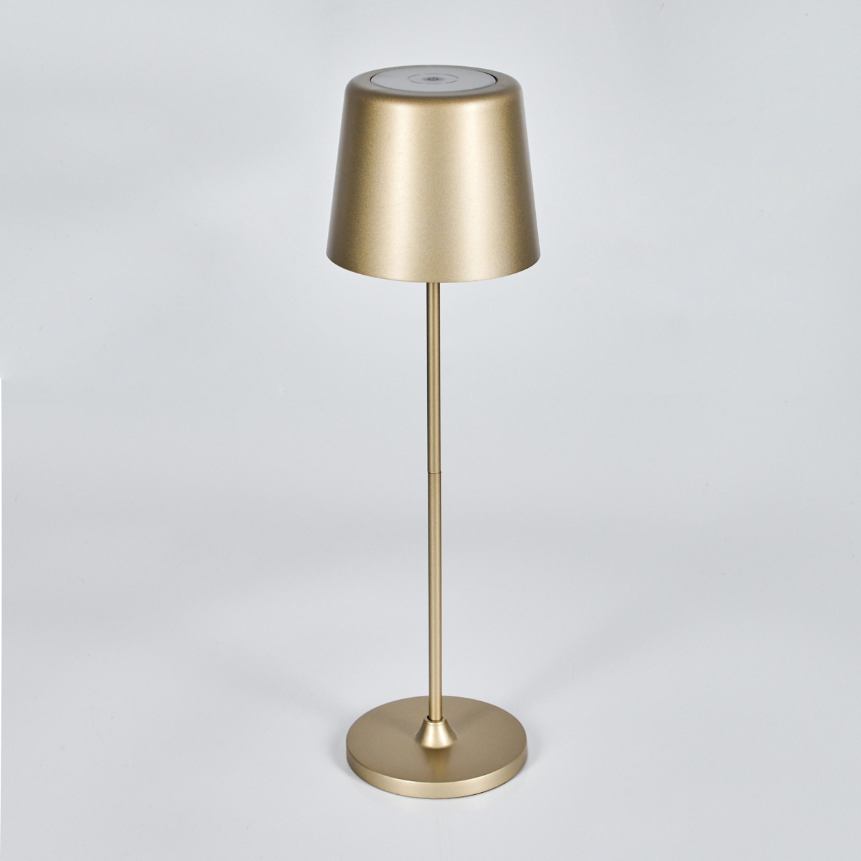 Eine schlanke, goldene Stehlampe mit rundem Fuß und kegelförmigem Schirm.
