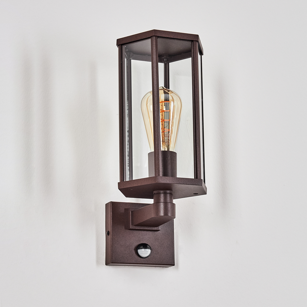 Braune Wandleuchte mit Glas und Glühbirne, Sensor an der Basis.