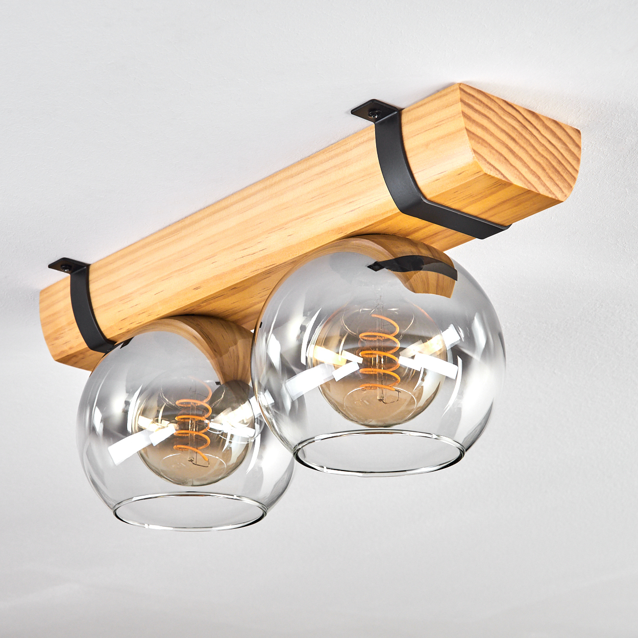 Holz-Deckenleuchte mit zwei Glaskugeln und sichtbaren Glühbirnen.