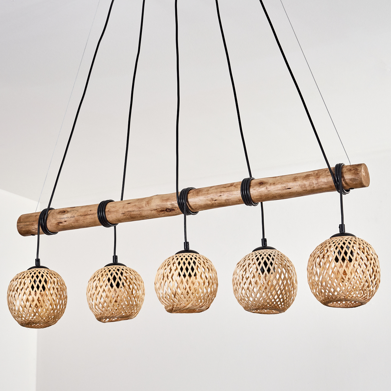 Hängelampe mit Holzbalken und fünf runden Korbschirmen.
