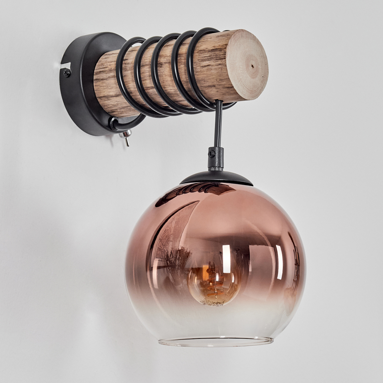 Eine Wandleuchte mit Holzbalken, schwarzen Spiralen und einem bronzefarbenen Glaskolben.