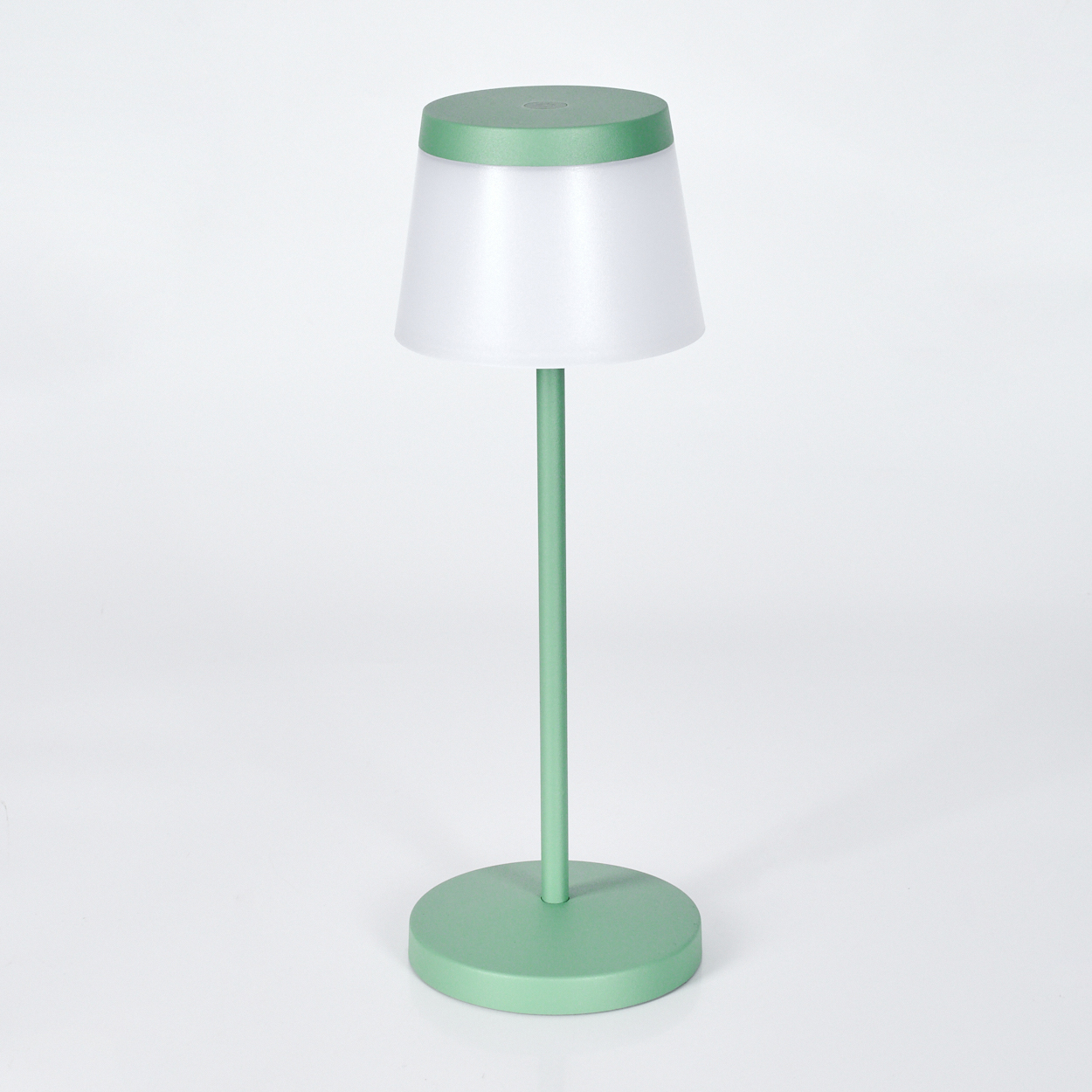 Eine grüne Tischlampe mit weißem Schirm steht auf einem runden Fuß.