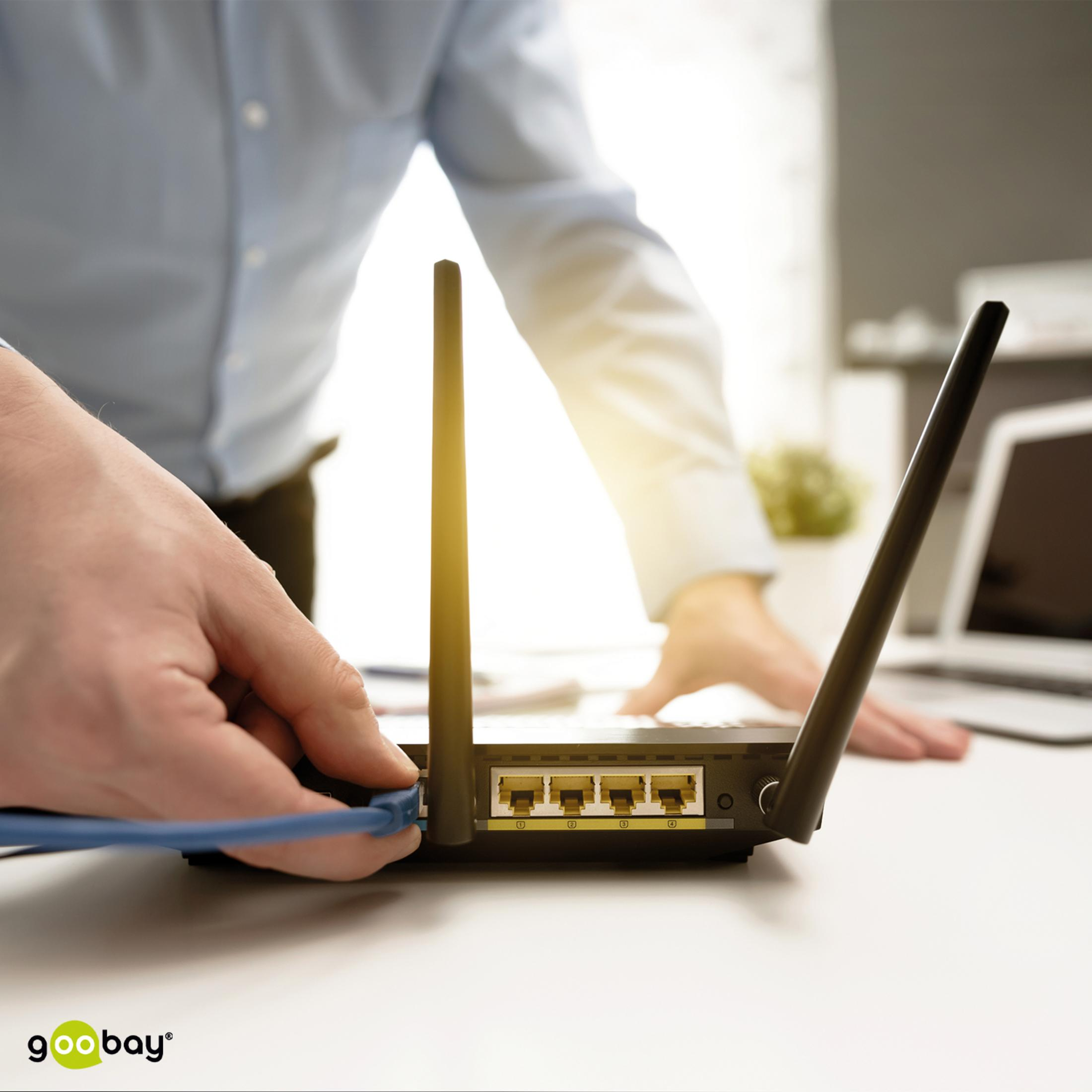 Primer plano de un hombre conectando un cable azul a un router Wi-Fi.