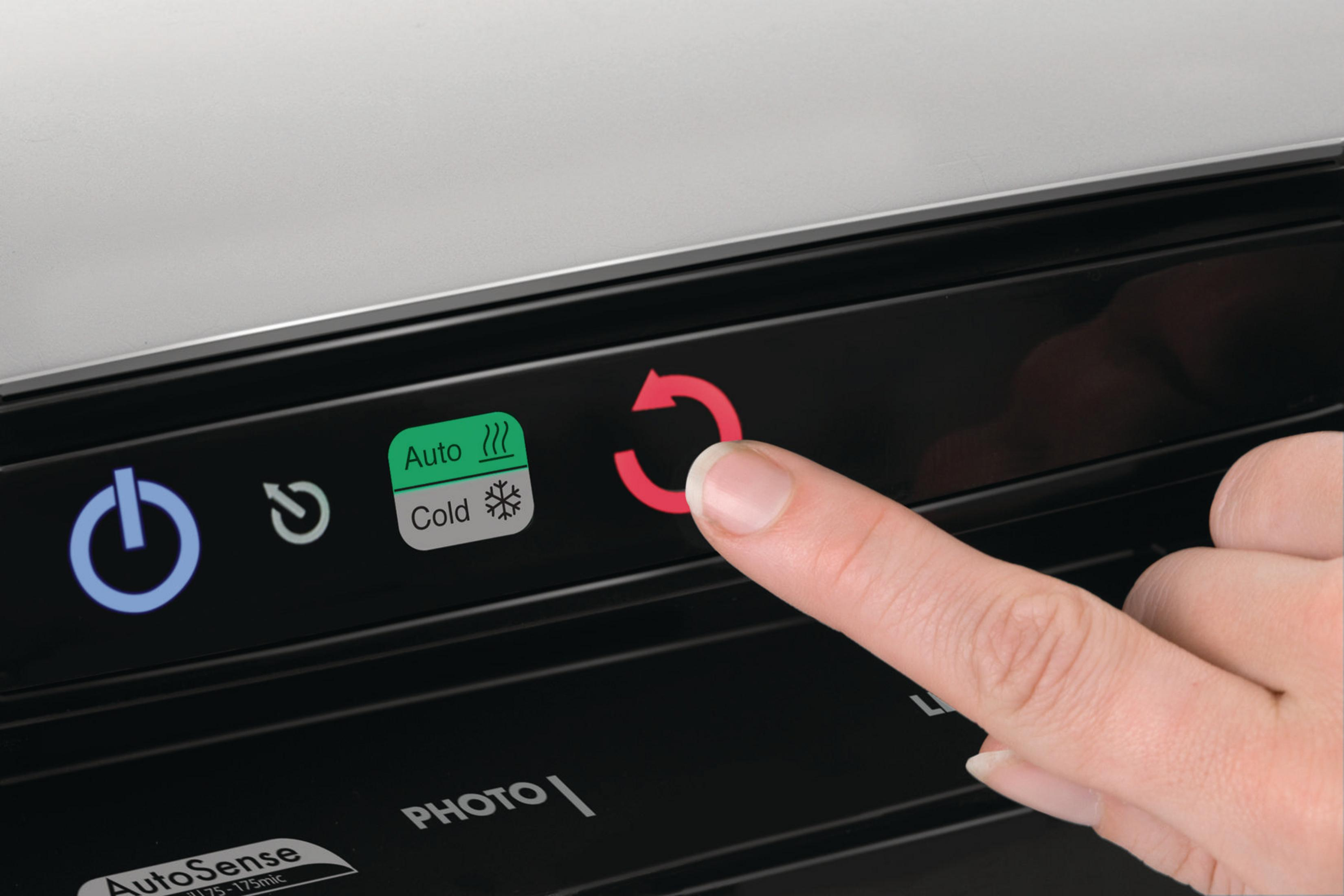 A finger presses a red arrow button on a control panel with icons.