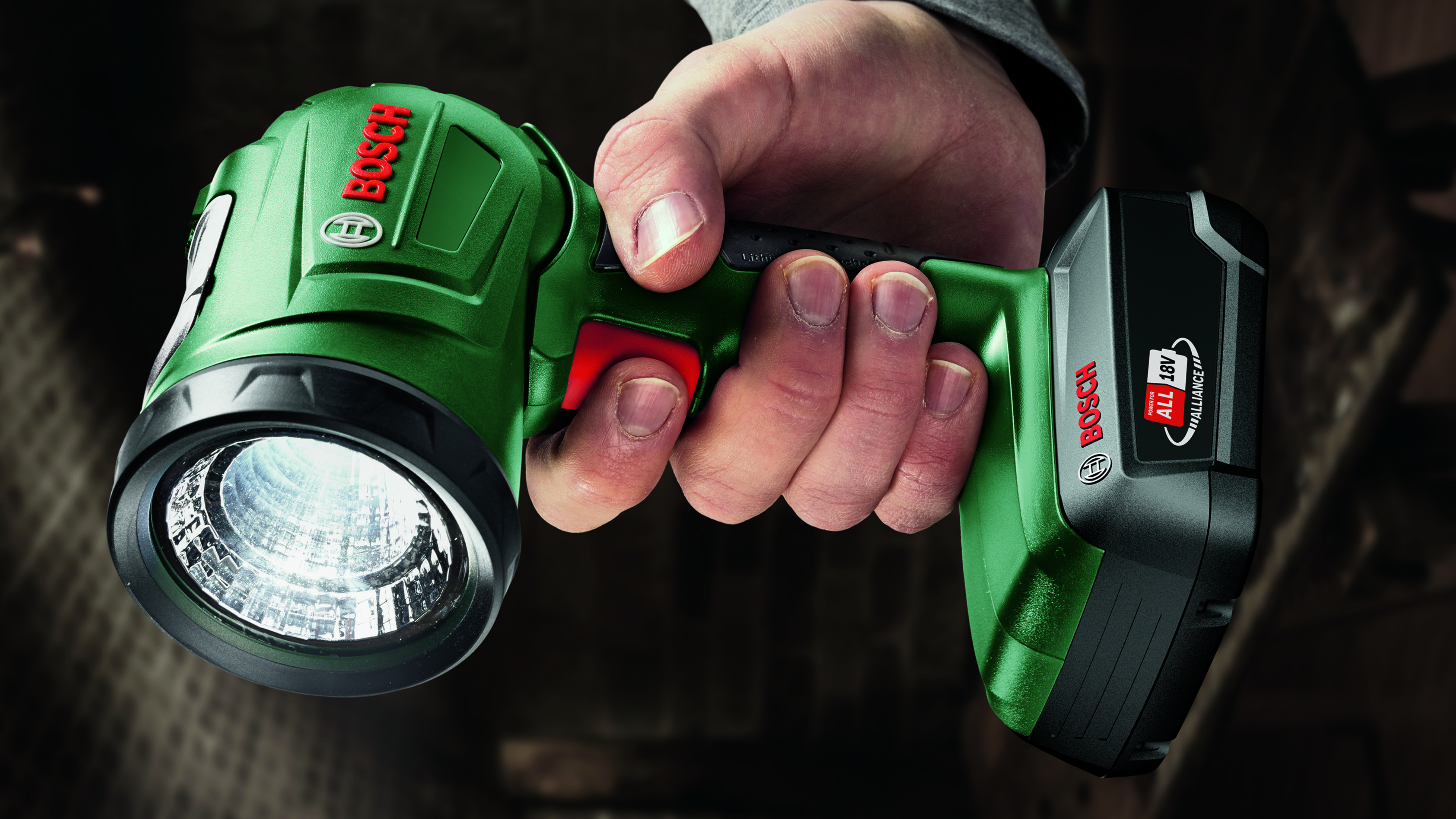 Eine Hand hält eine grüne Bosch-Taschenlampe mit hellem LED-Licht. Der Akku zeigt '18V ALLIANCE'.