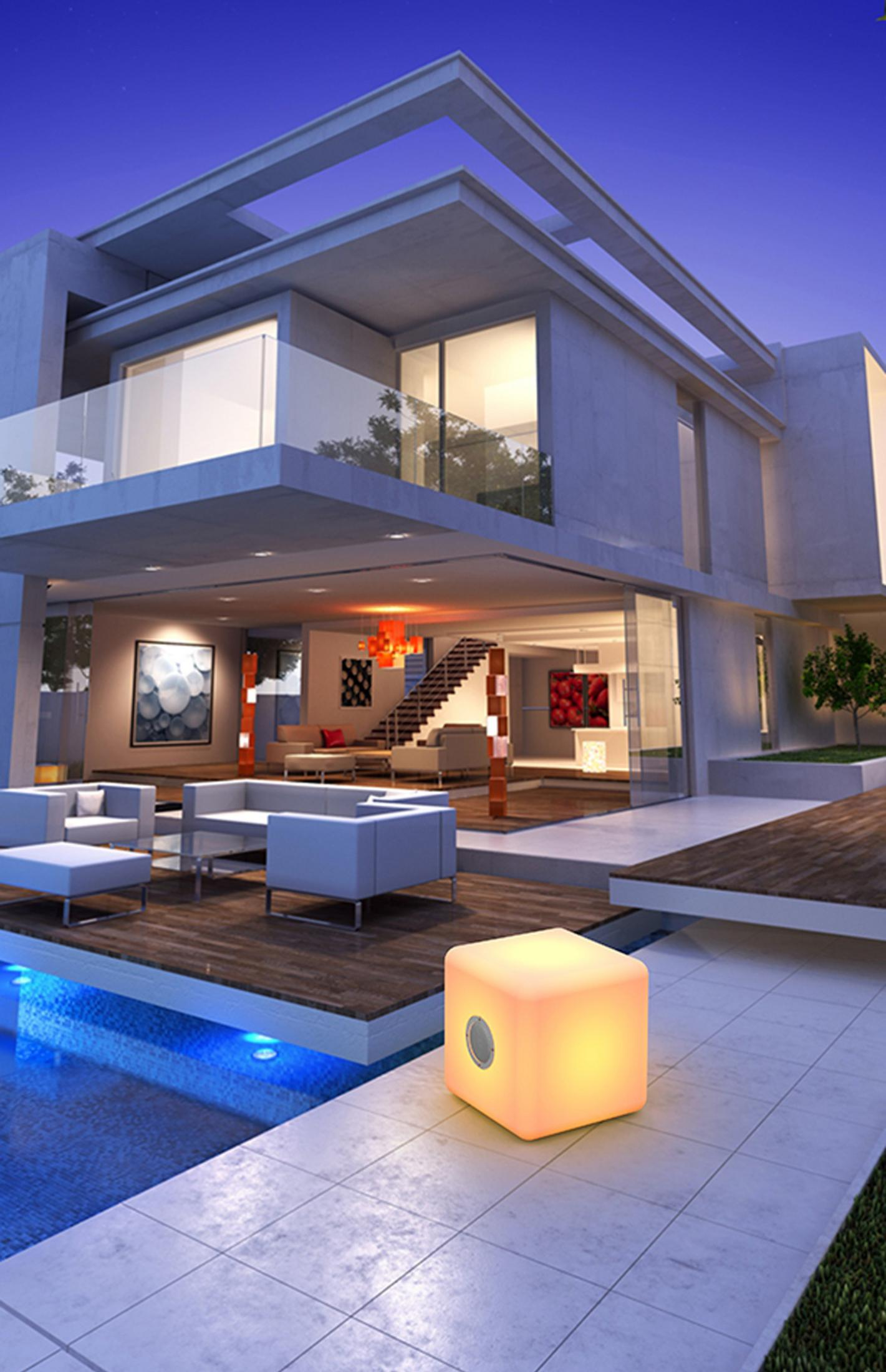 Villa moderna con piscina, cubo illuminato e zona salotto esterna di notte.