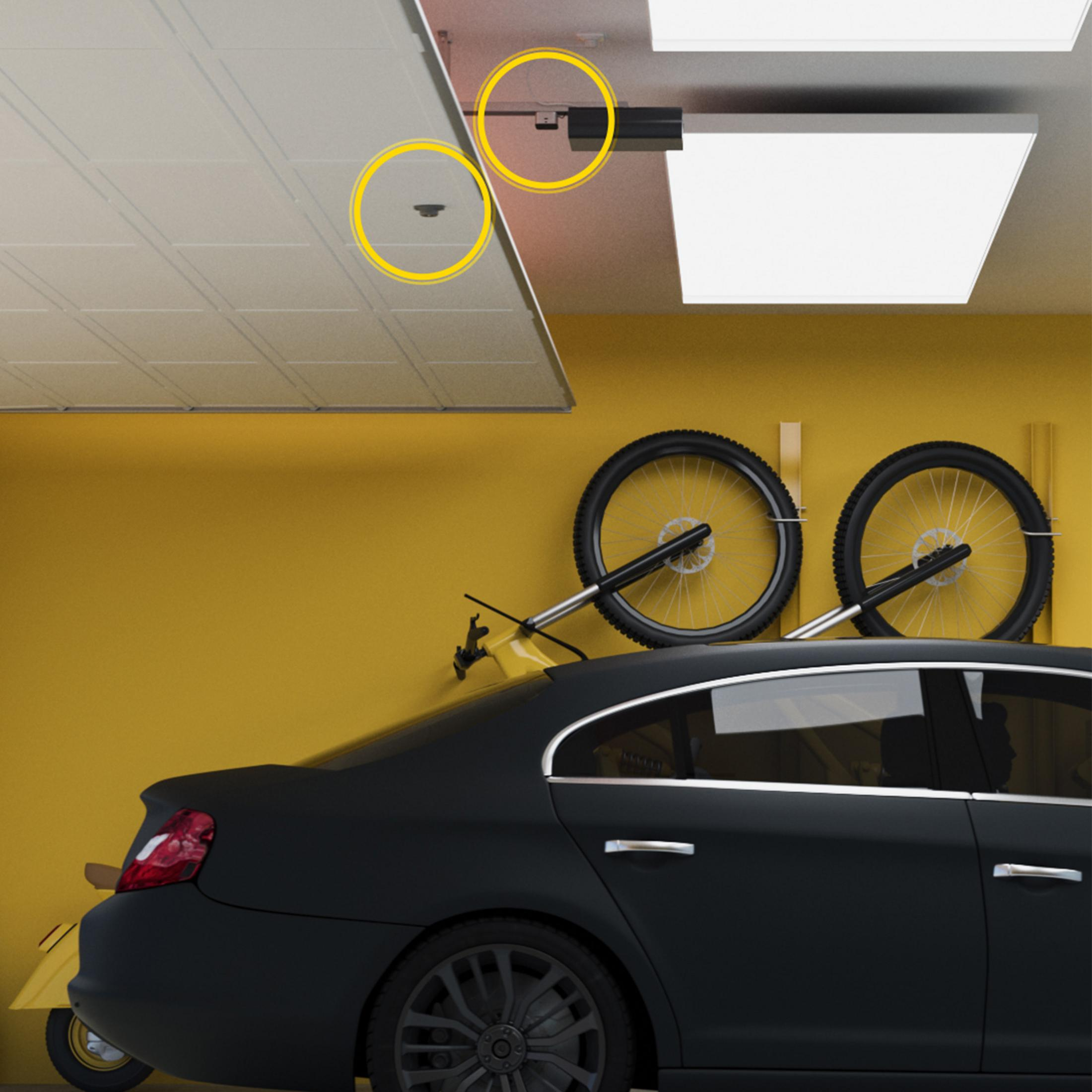 Un'auto nera e biciclette in un garage giallo.