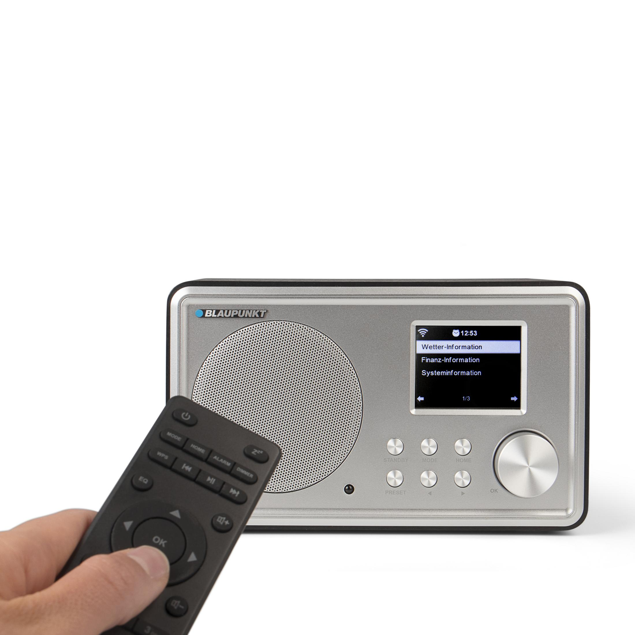 Una radio Blaupunkt argentata con telecomando. Un dito preme il pulsante OK.