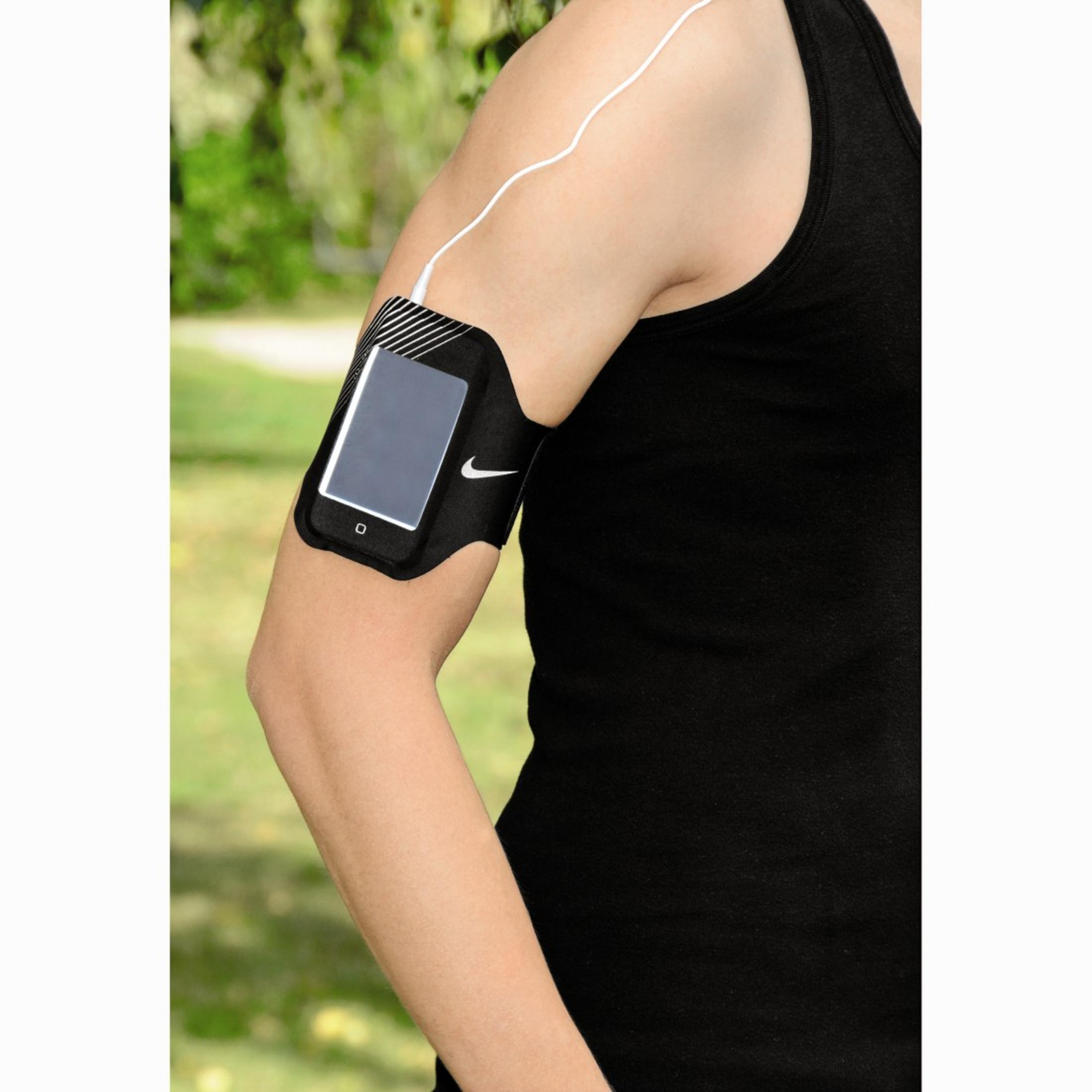 Ein Arm trägt eine schwarze Nike-Armtasche mit einem Smartphone und Kopfhörerkabel.