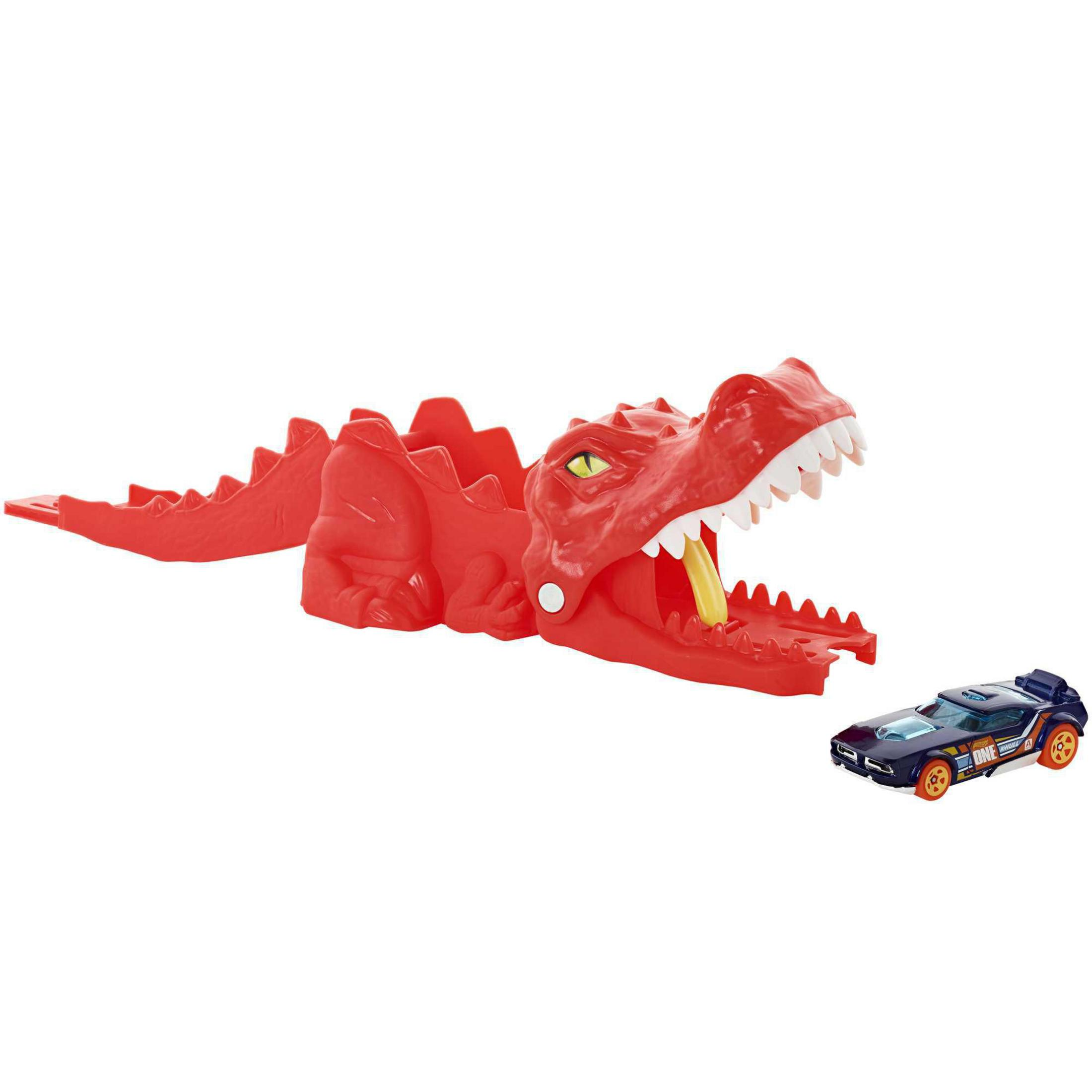 Ein roter Krokodilspielzeug-Launcher mit einem blauen Hot Wheels Auto daneben.