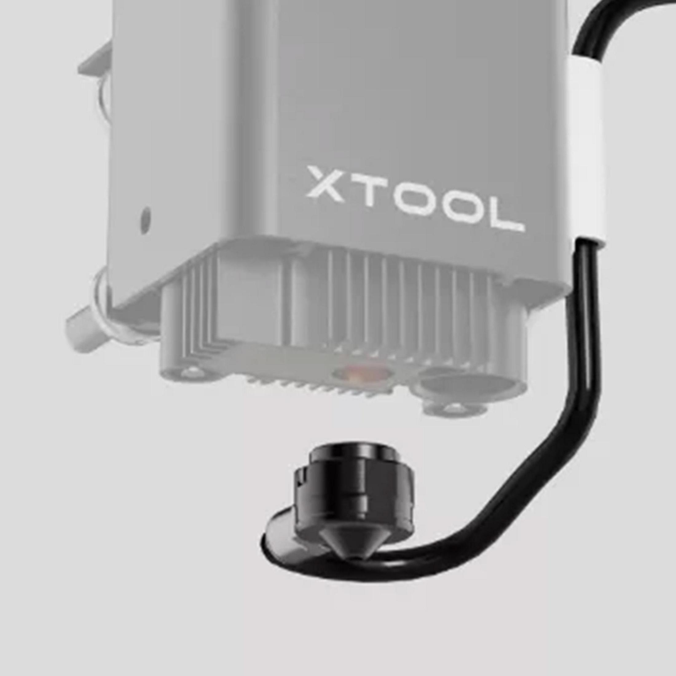 Nahaufnahme eines silbernen XTool-Laserkopfes mit schwarzer Düse und Kabel.
