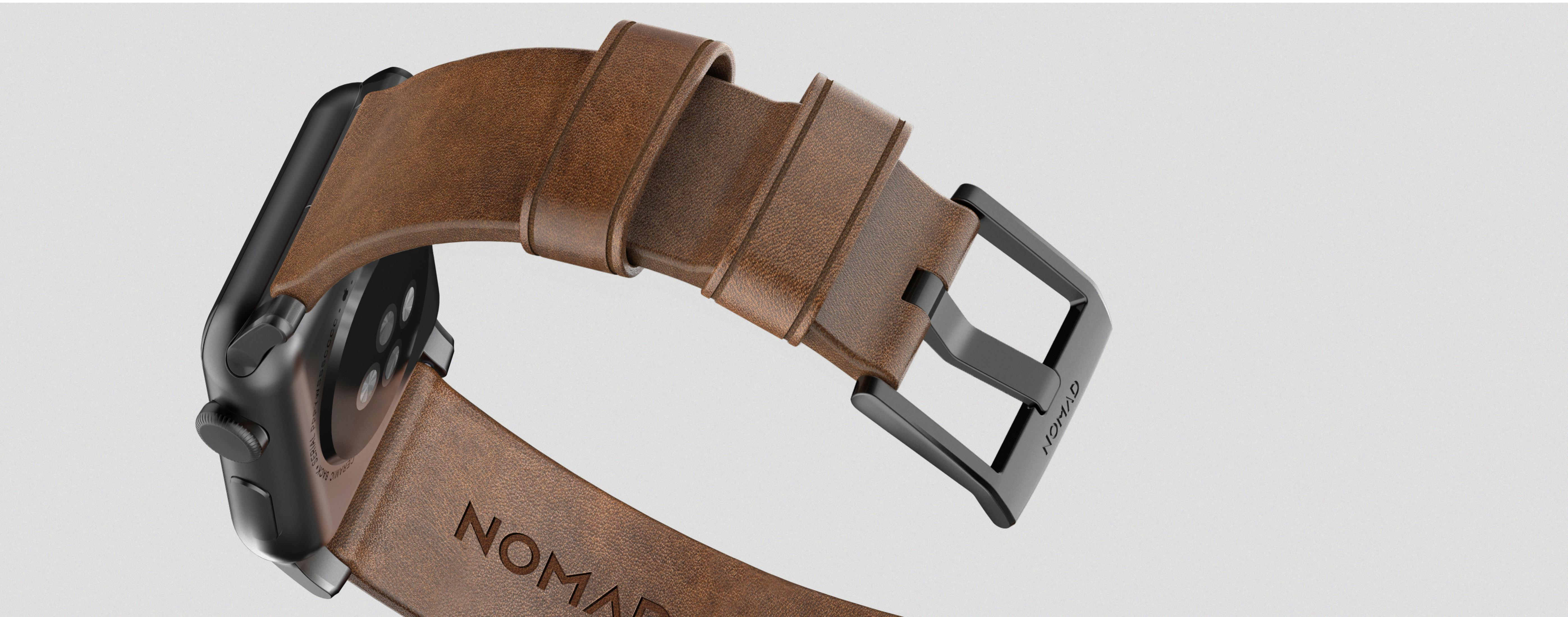 Eine Nahaufnahme einer Smartwatch mit braunem Lederarmband und schwarzer Schnalle.