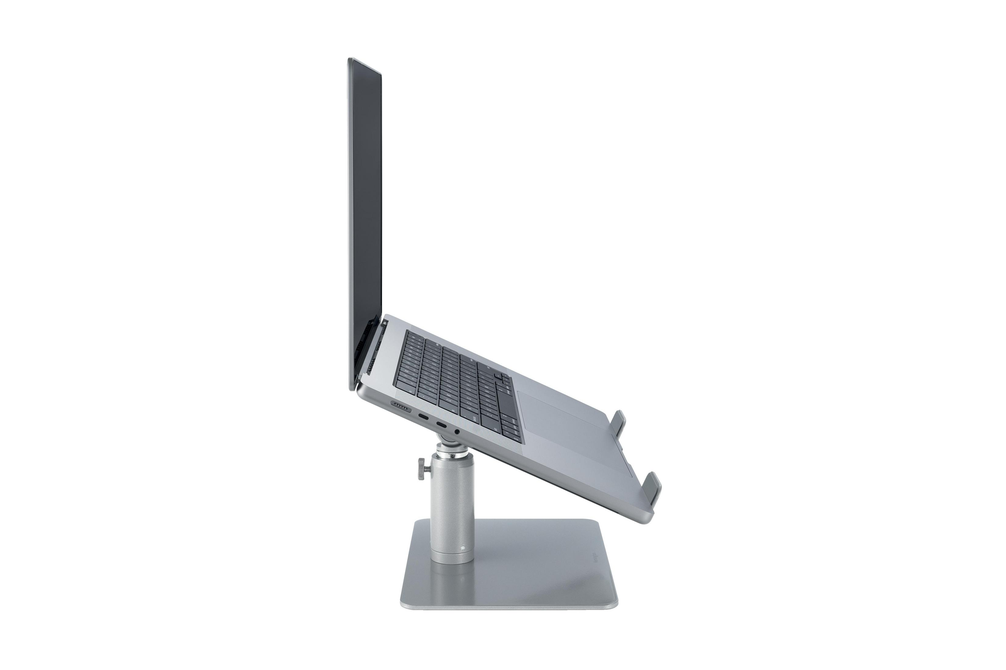 Een zilveren laptopstandaard met laptop, van opzij gezien.