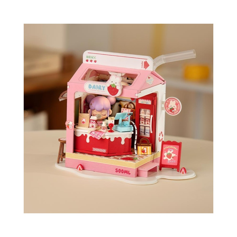 Set da gioco negozio latticini rosa con bambola, bottiglie di latte e cartello fragola.