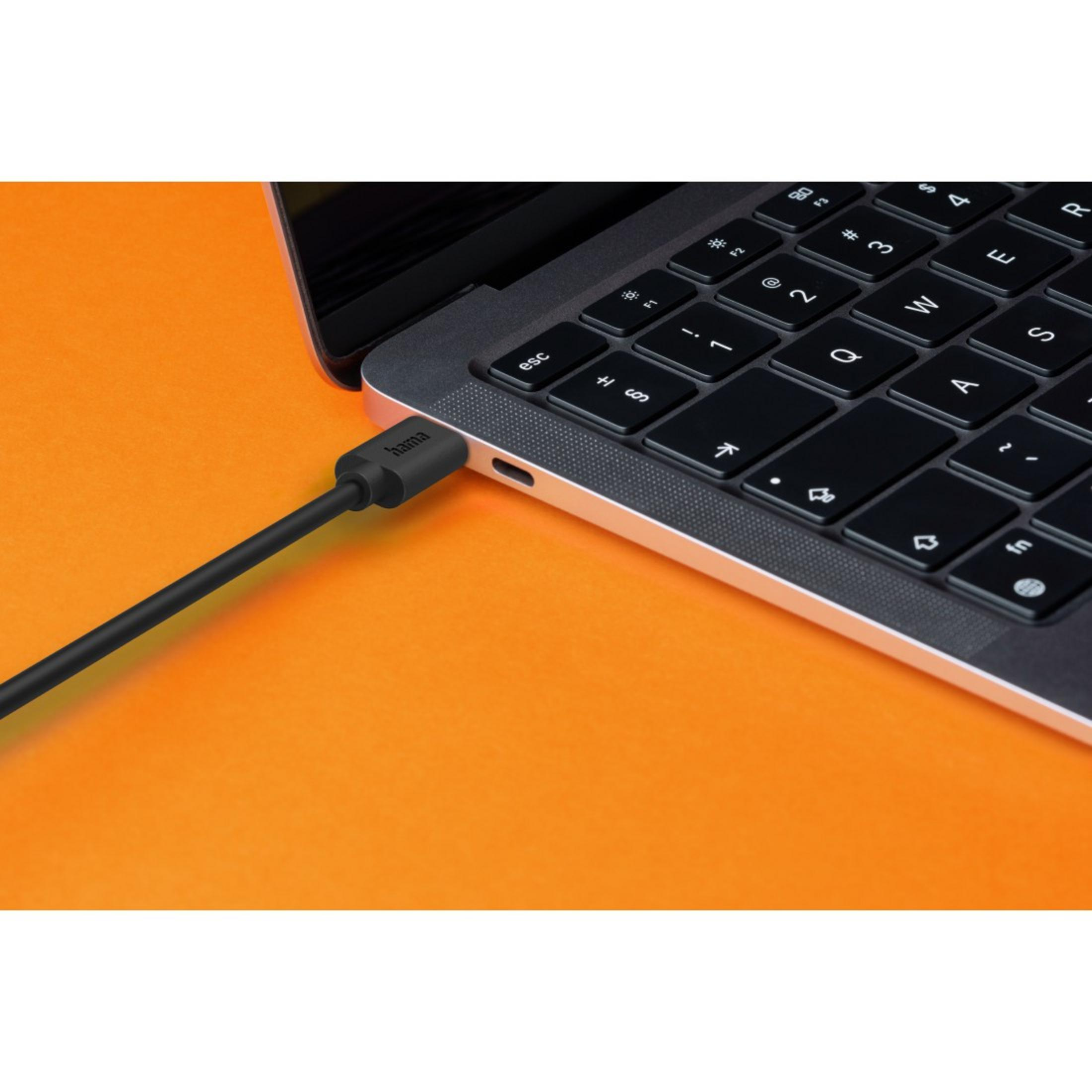 Un cavo di ricarica nero collegato a un laptop su sfondo arancione.