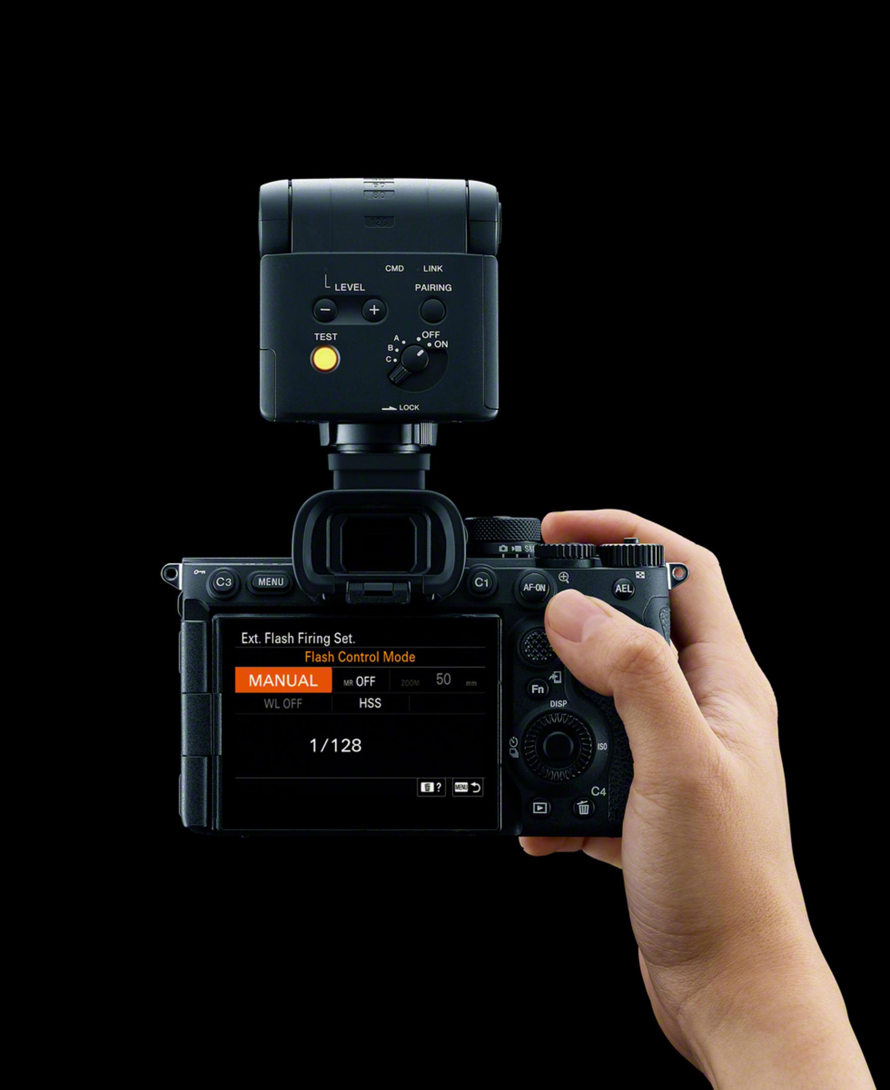 Una mano tiene una fotocamera con flash. Lo schermo mostra le impostazioni flash.