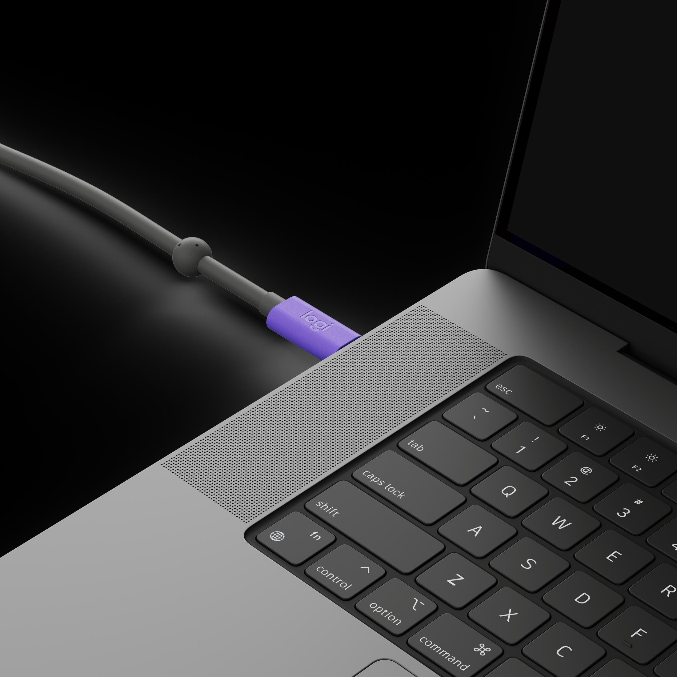 Cavo Logi viola collegato a un laptop su sfondo nero.