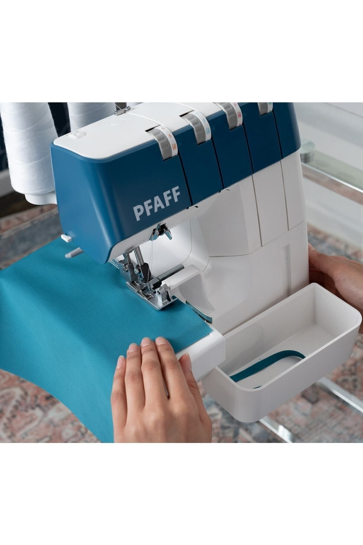 Pfaff overlok dikiş makinesi, mavi-beyaz kasalı, turkuaz kumaş dikiyor. Eller kumaşı yönlendiriyor.
