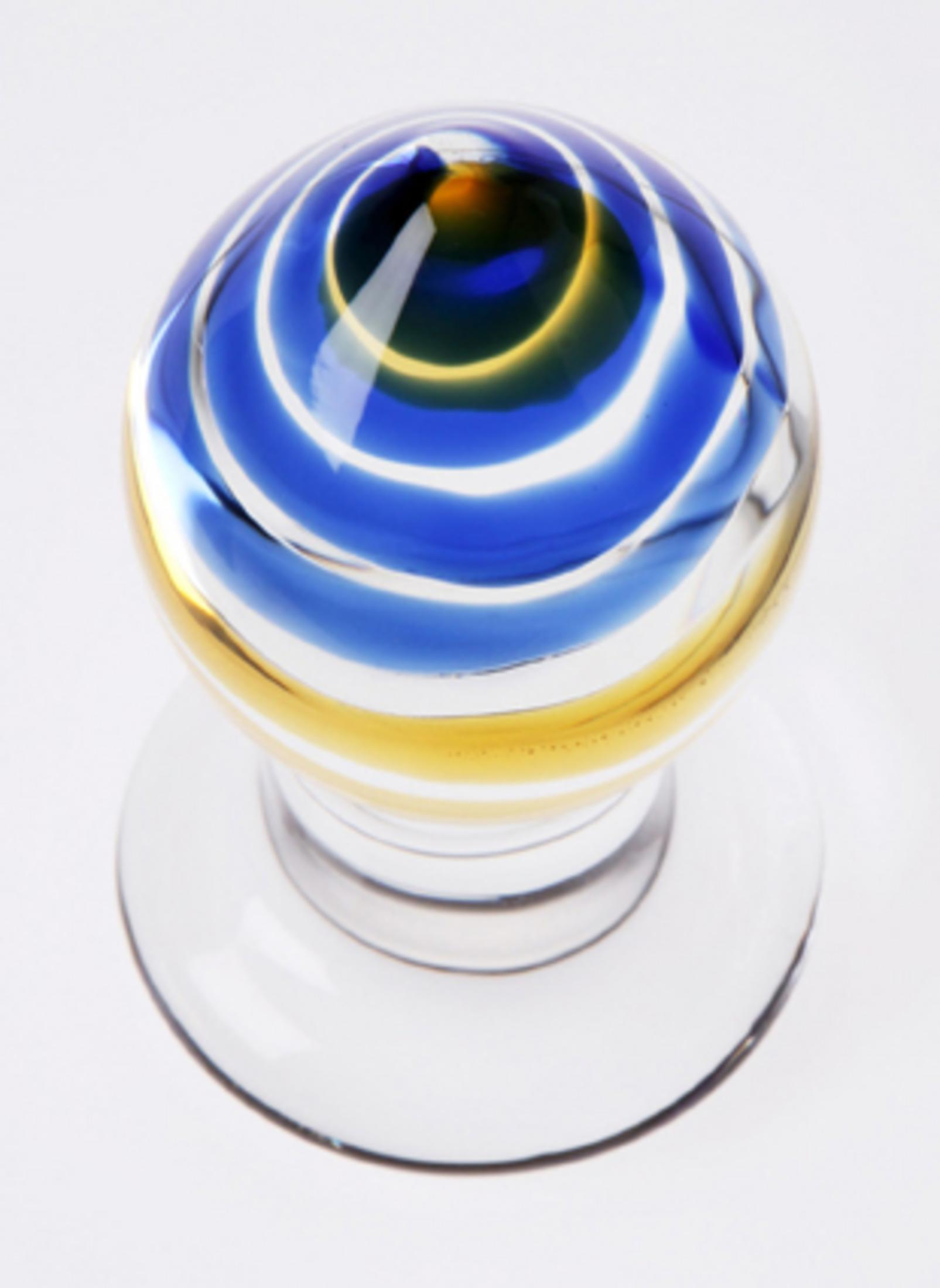 Klarer Glasgriff mit blauen und gelben Spiralen auf weißem Hintergrund.