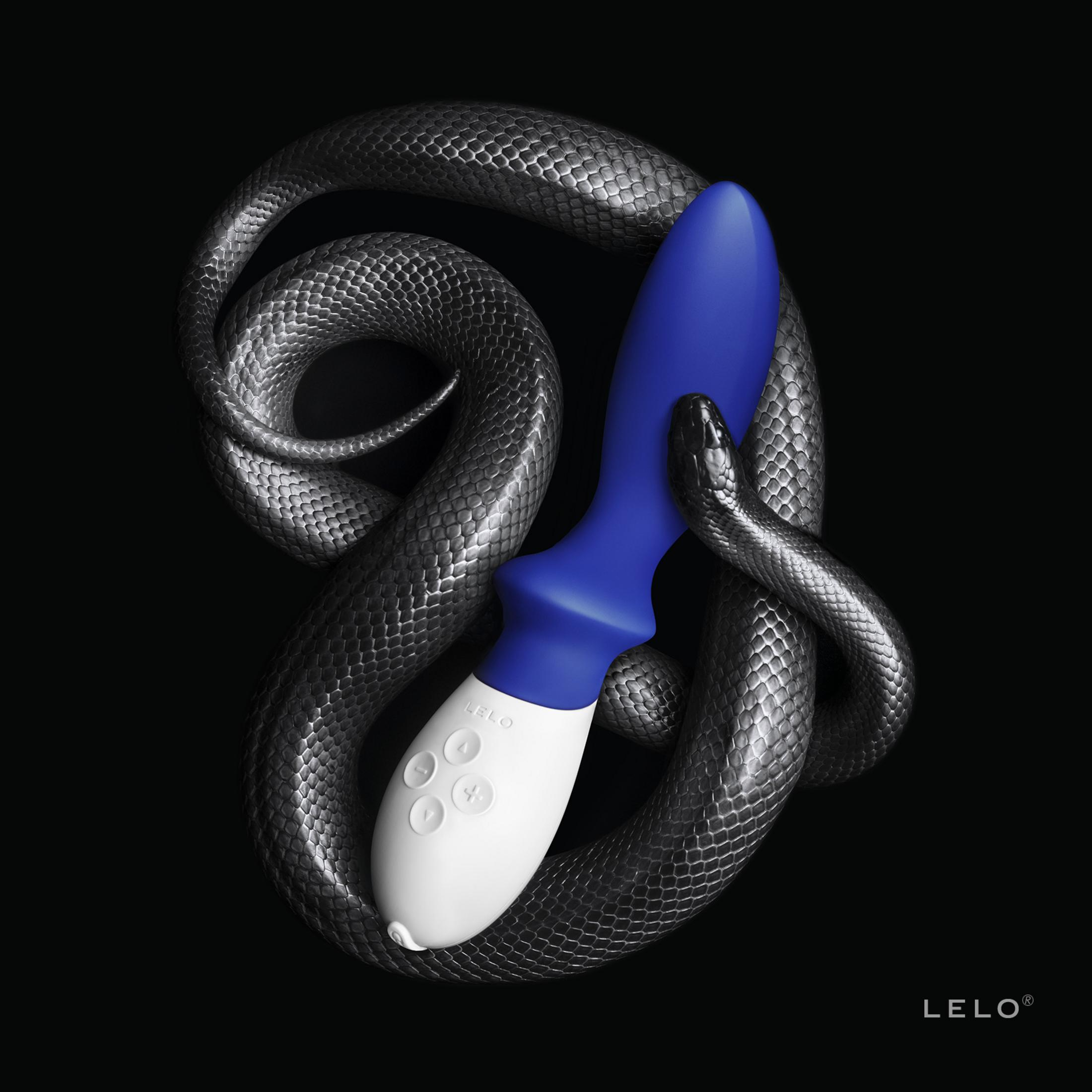 Una serpiente se enrolla alrededor de un vibrador azul y blanco sobre fondo negro.
