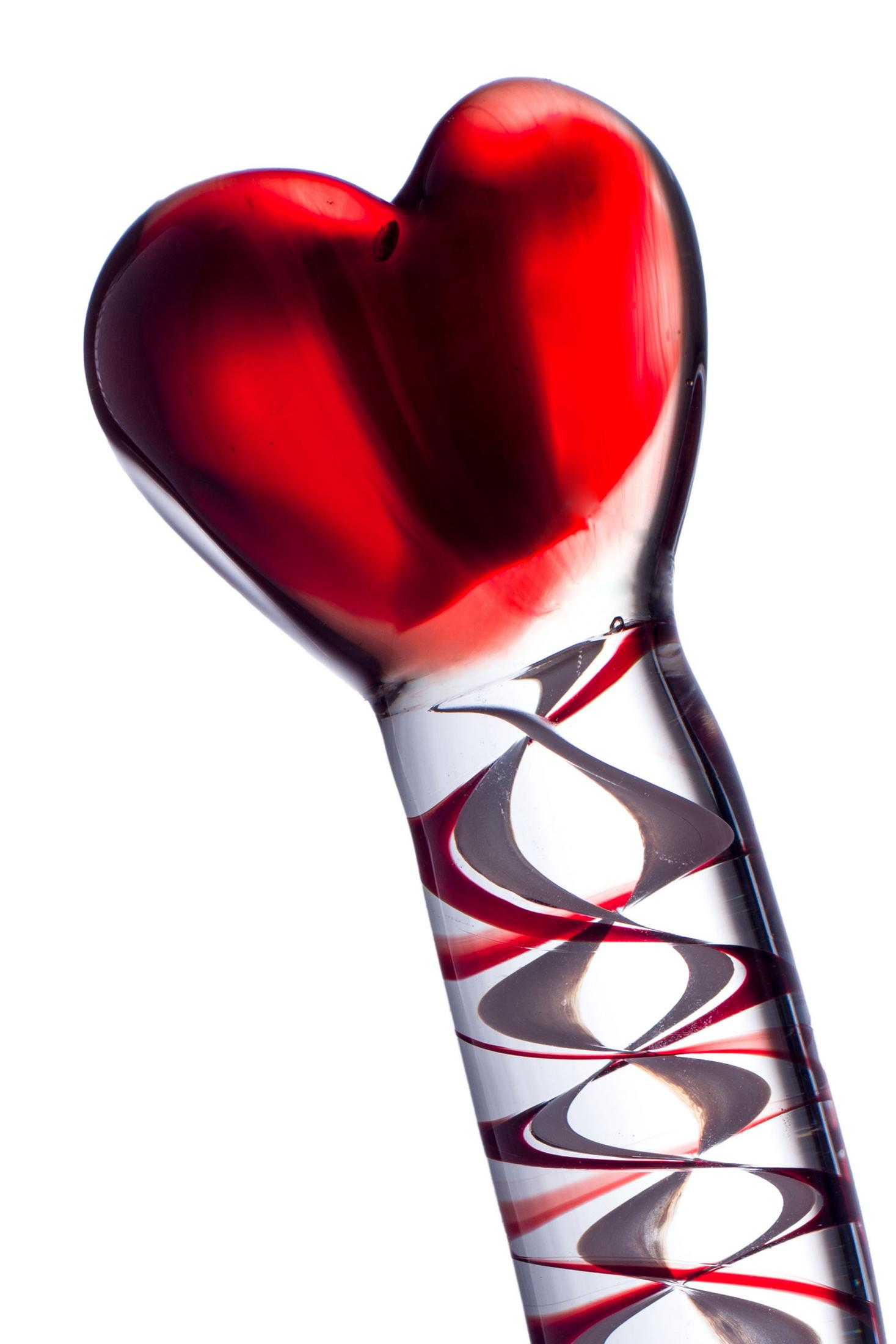 Ein rotes Herz aus Glas mit Spiralmustern auf einem weißen Hintergrund.