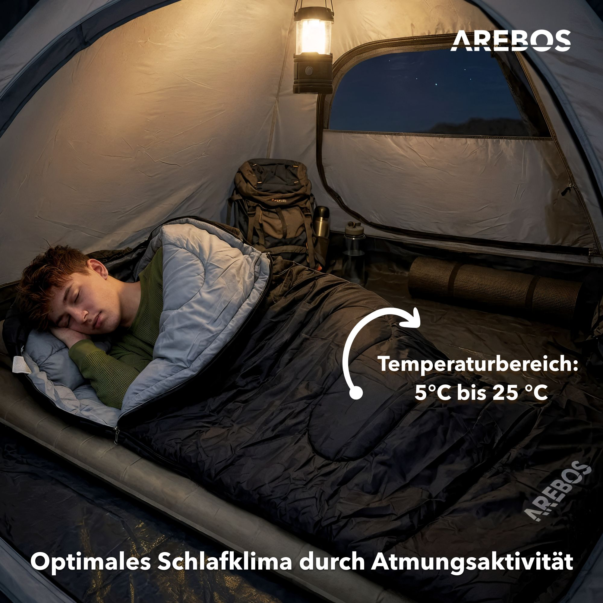 Ein Mann schläft in einem Zelt in einem Schlafsack. Ein Campinglicht hängt.