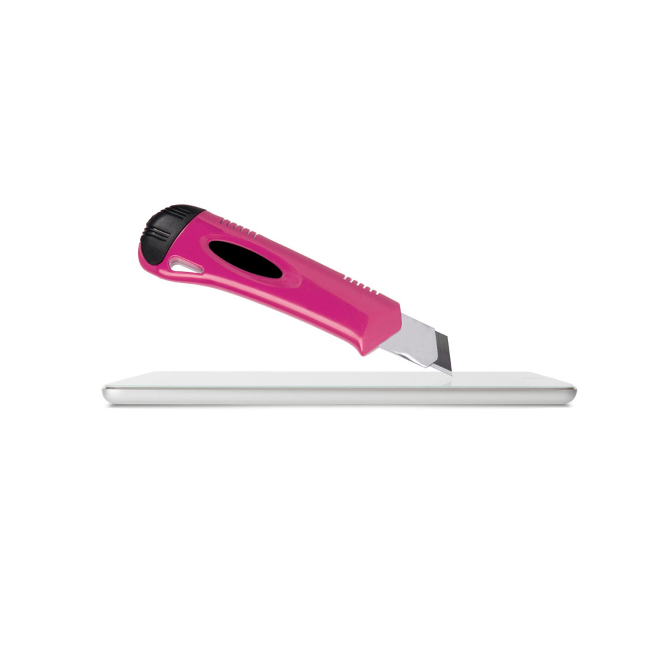 Un taglierino rosa taglia un oggetto bianco piatto.