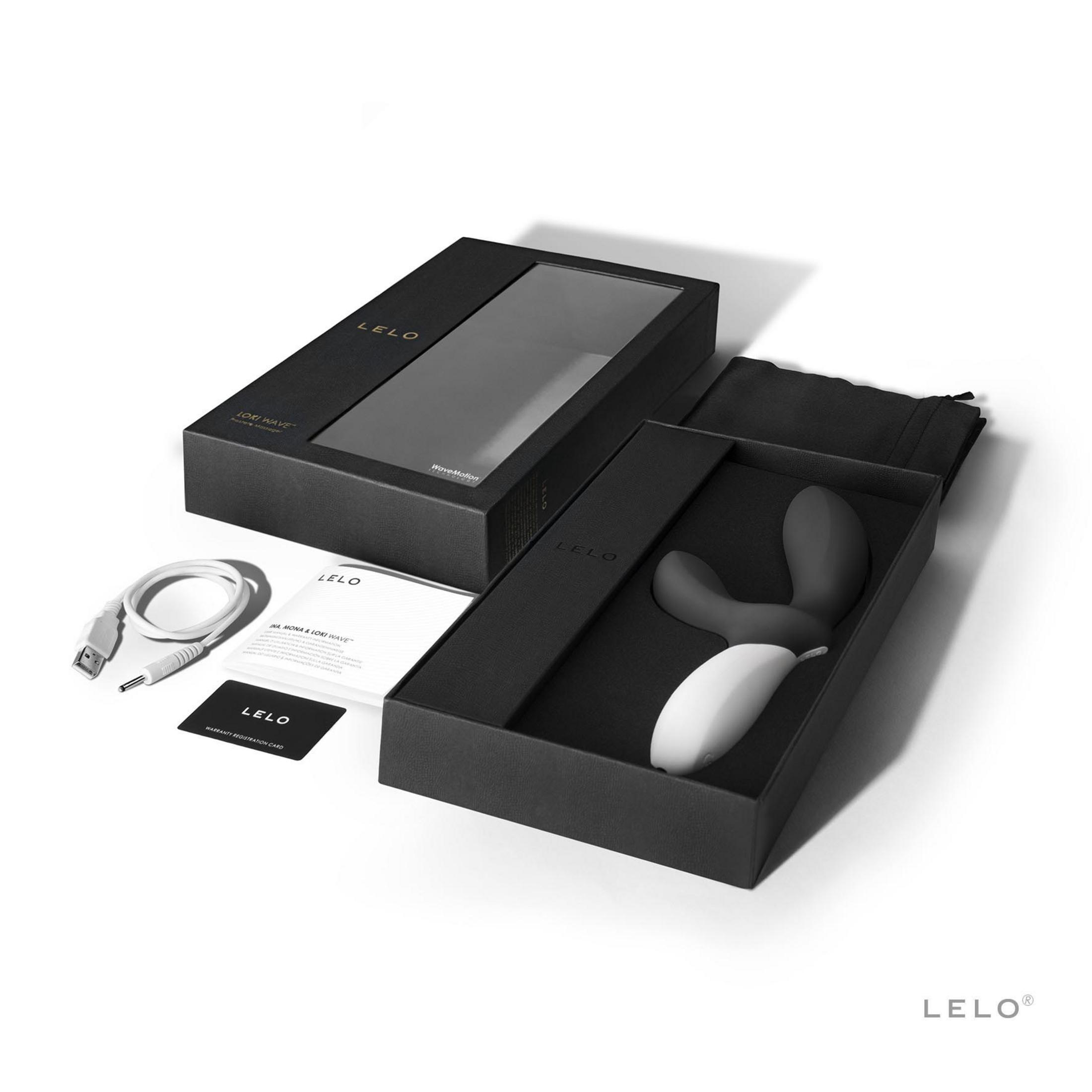 Una caja negra que contiene un masajeador, cable USB y manual de instrucciones.