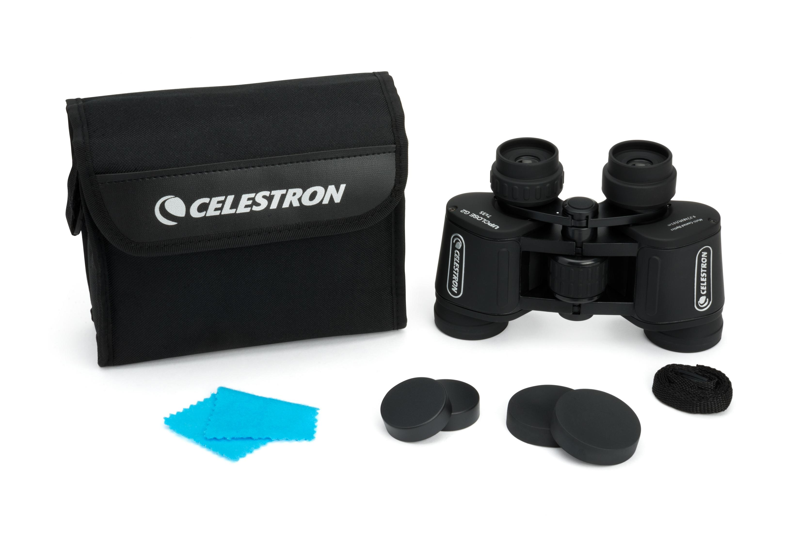 Schwarze Celestron Ferngläser mit Tasche, Linsenabdeckungen und Riemen auf weißem Hintergrund.