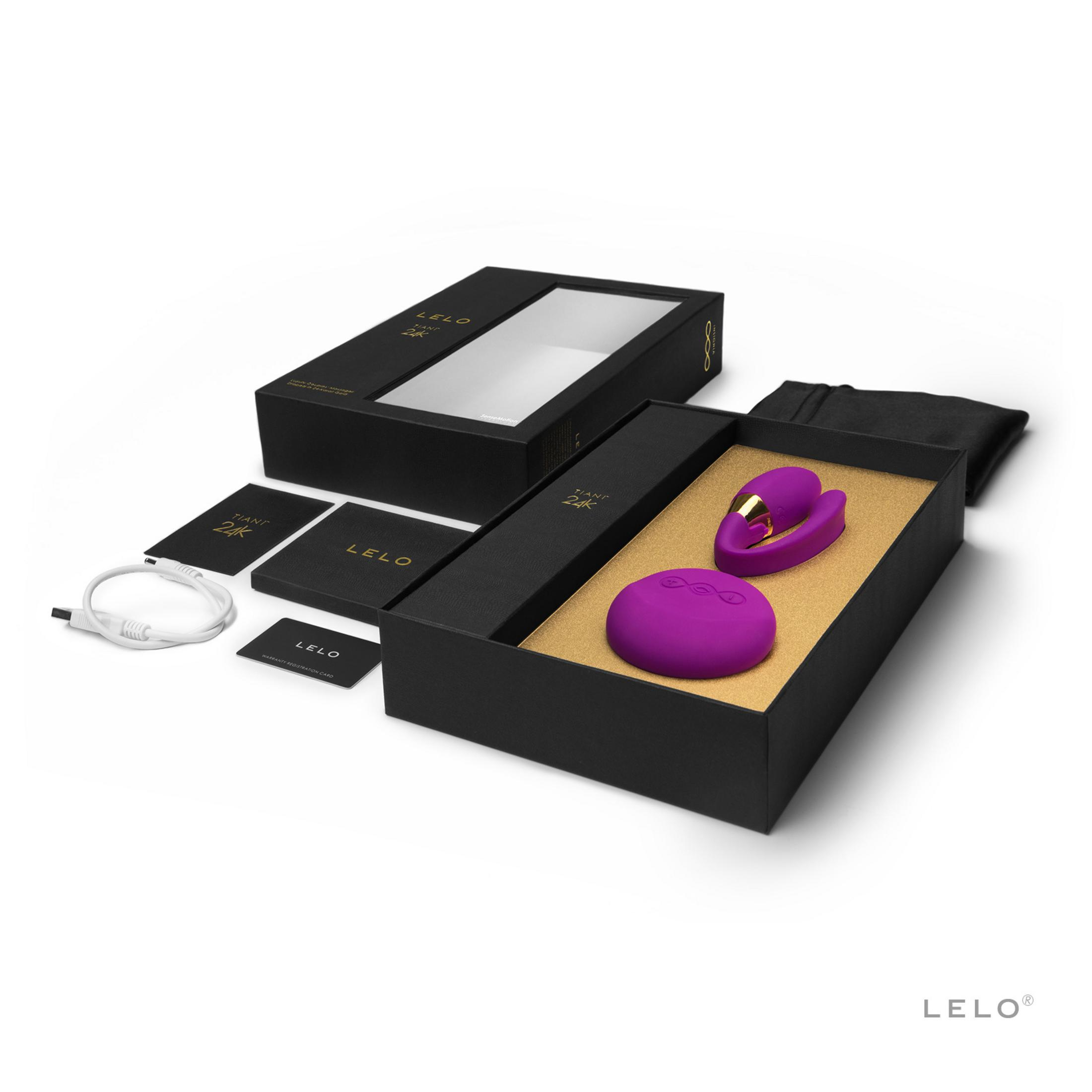 Un vibrador morado y cable de carga en caja de regalo negra.
