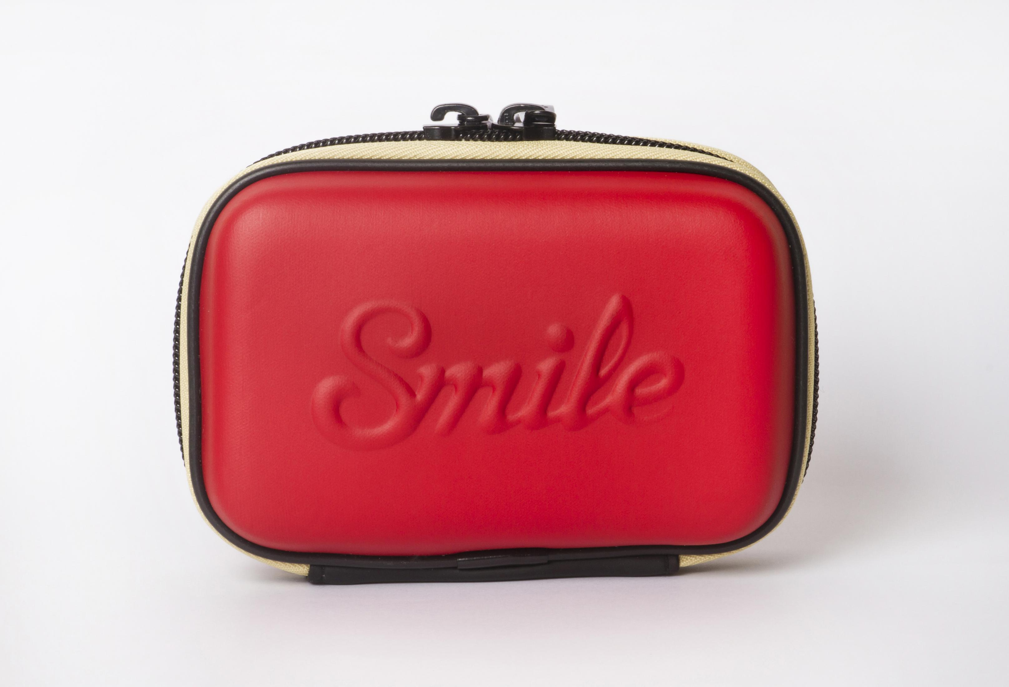 Rotes Etui mit der Aufschrift "Smile" und Reißverschluss auf weißem Hintergrund.
