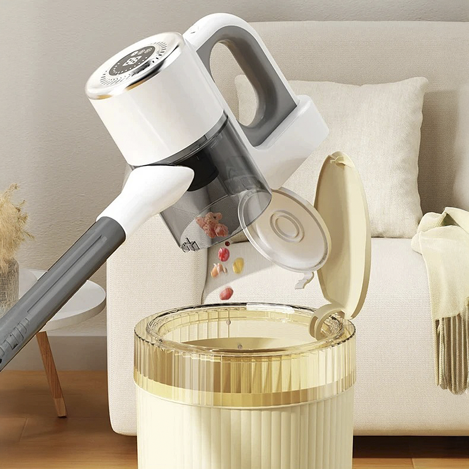 Un aspirapolvere bianco senza fili svuota detriti in un cestino beige con bordo dorato.