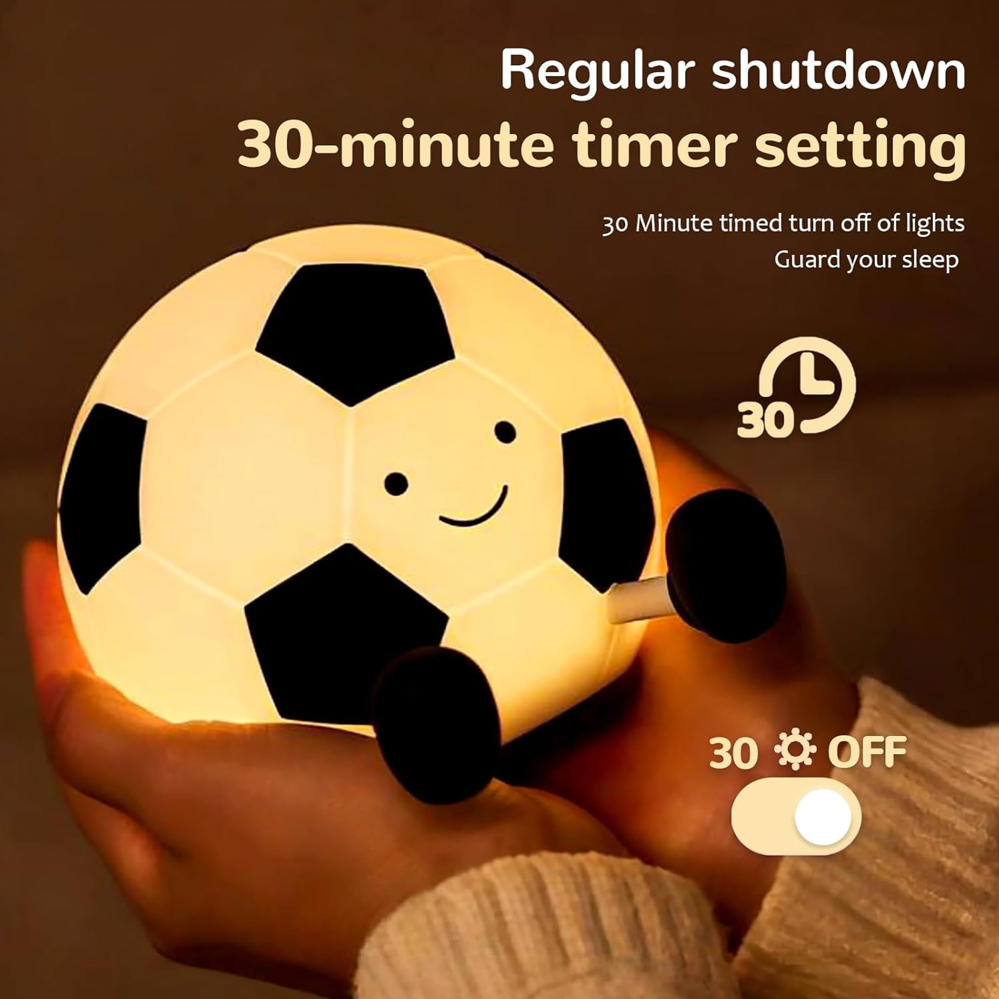 Eine leuchtende Fußballlampe mit einem niedlichen Gesicht, gehalten von Händen.