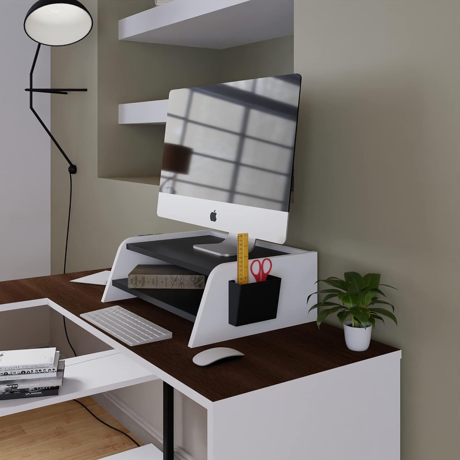 Configuración de escritorio moderna con iMac de Apple, teclado, ratón, planta y lámpara.