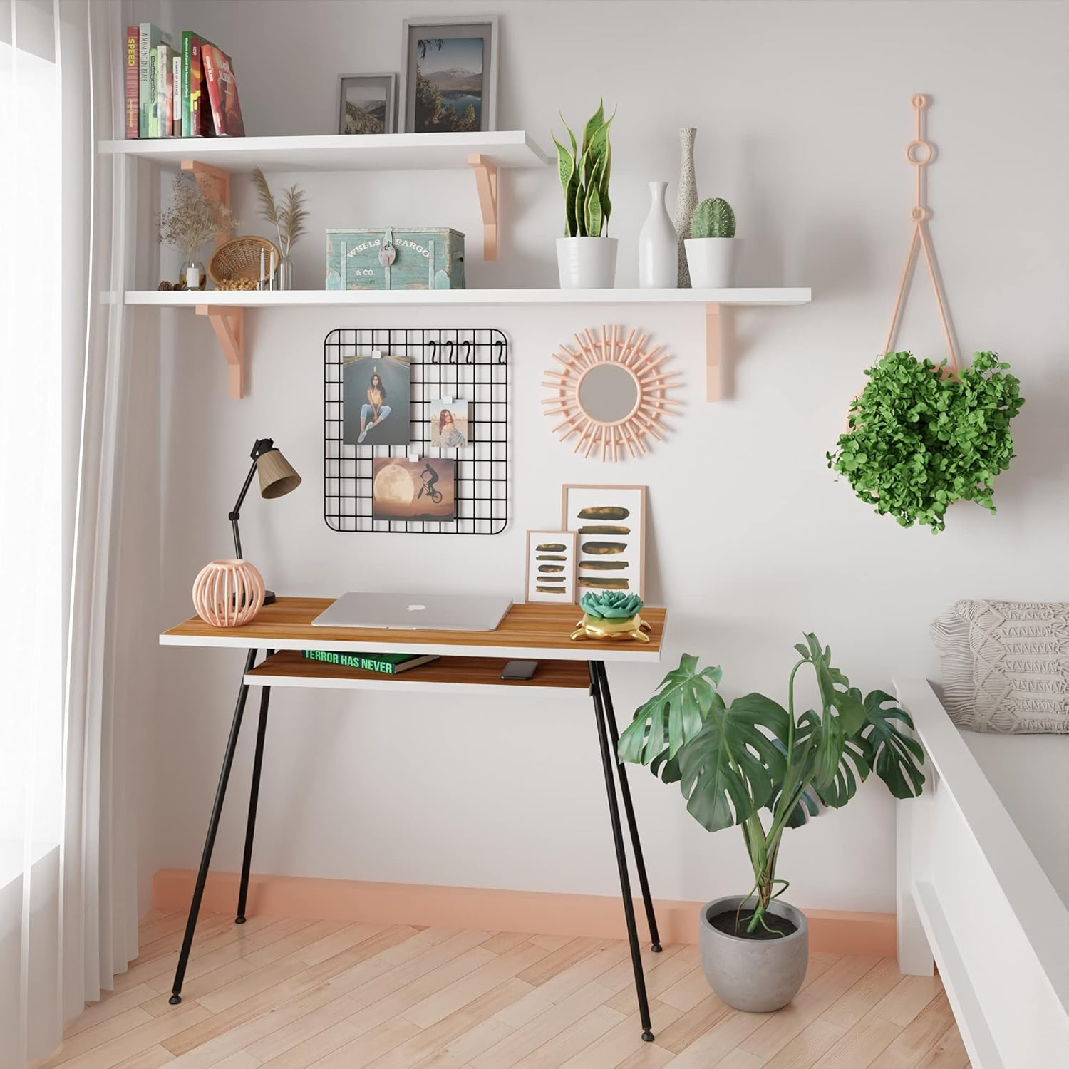 Un escritorio con laptop, lámpara y plantas contra una pared con estantes.