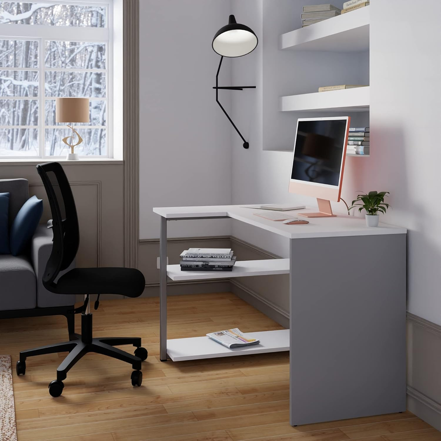 Un espacio de trabajo moderno con escritorio blanco, monitor, estanterías y ventana.