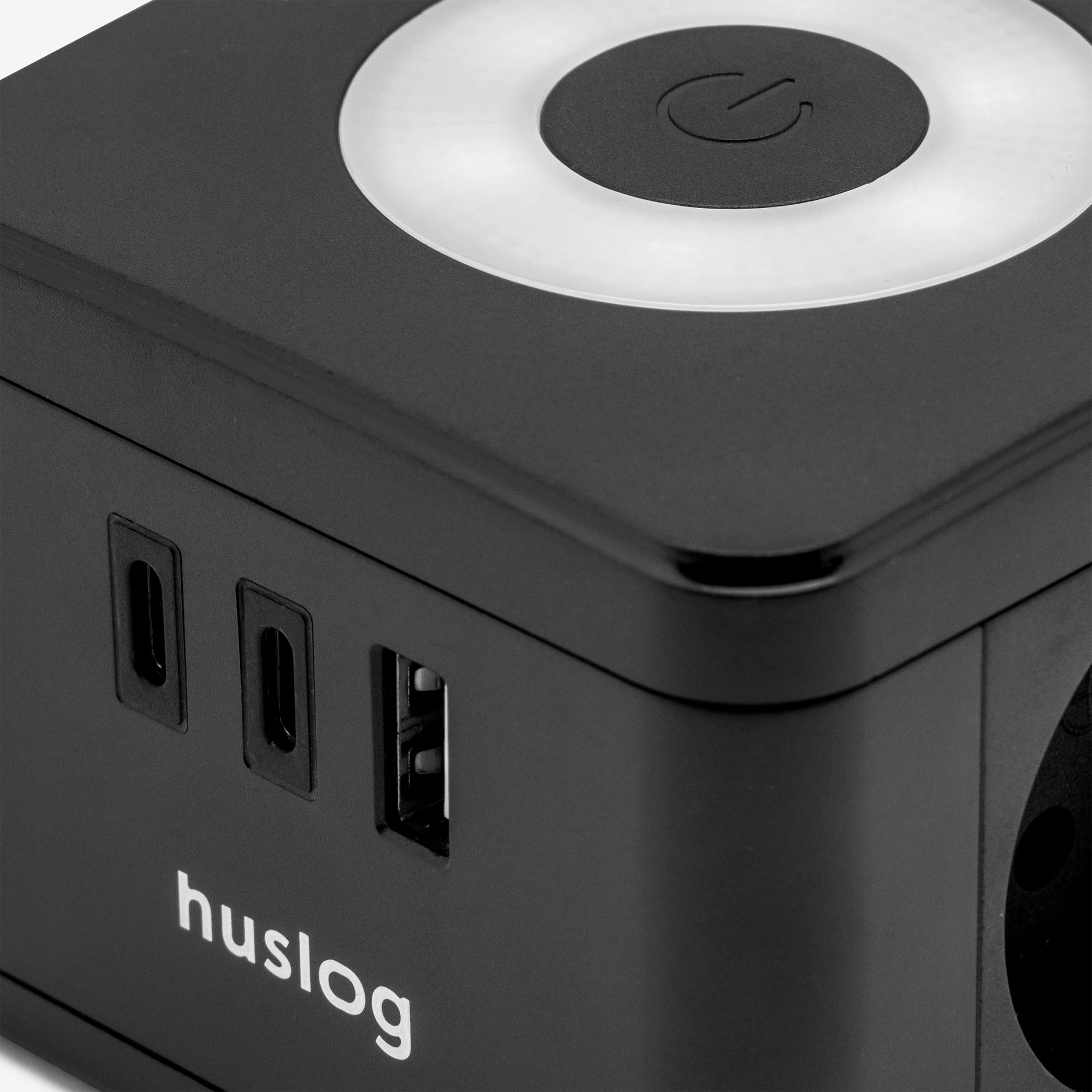 Czarne urządzenie z portami USB-C, USB-A i symbolem zasilania. Logo Huslog.