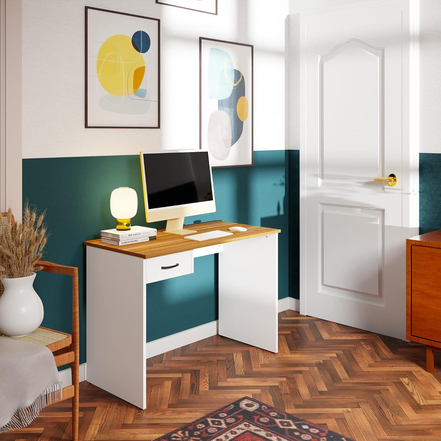 Un escritorio minimalista con computadora, lámpara y libros se apoya contra una pared turquesa.