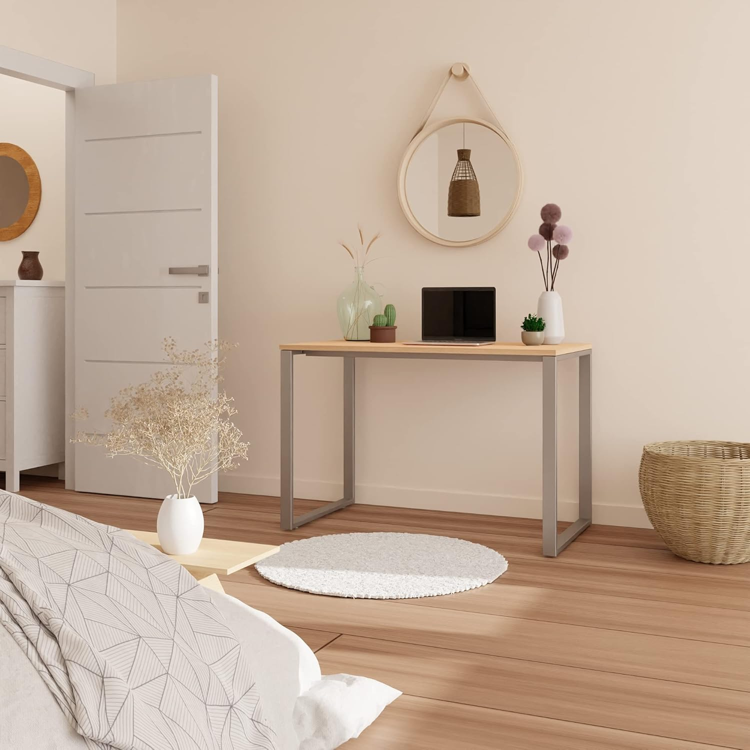 Un dormitorio con escritorio, portátil, cesta, espejo y puerta.
