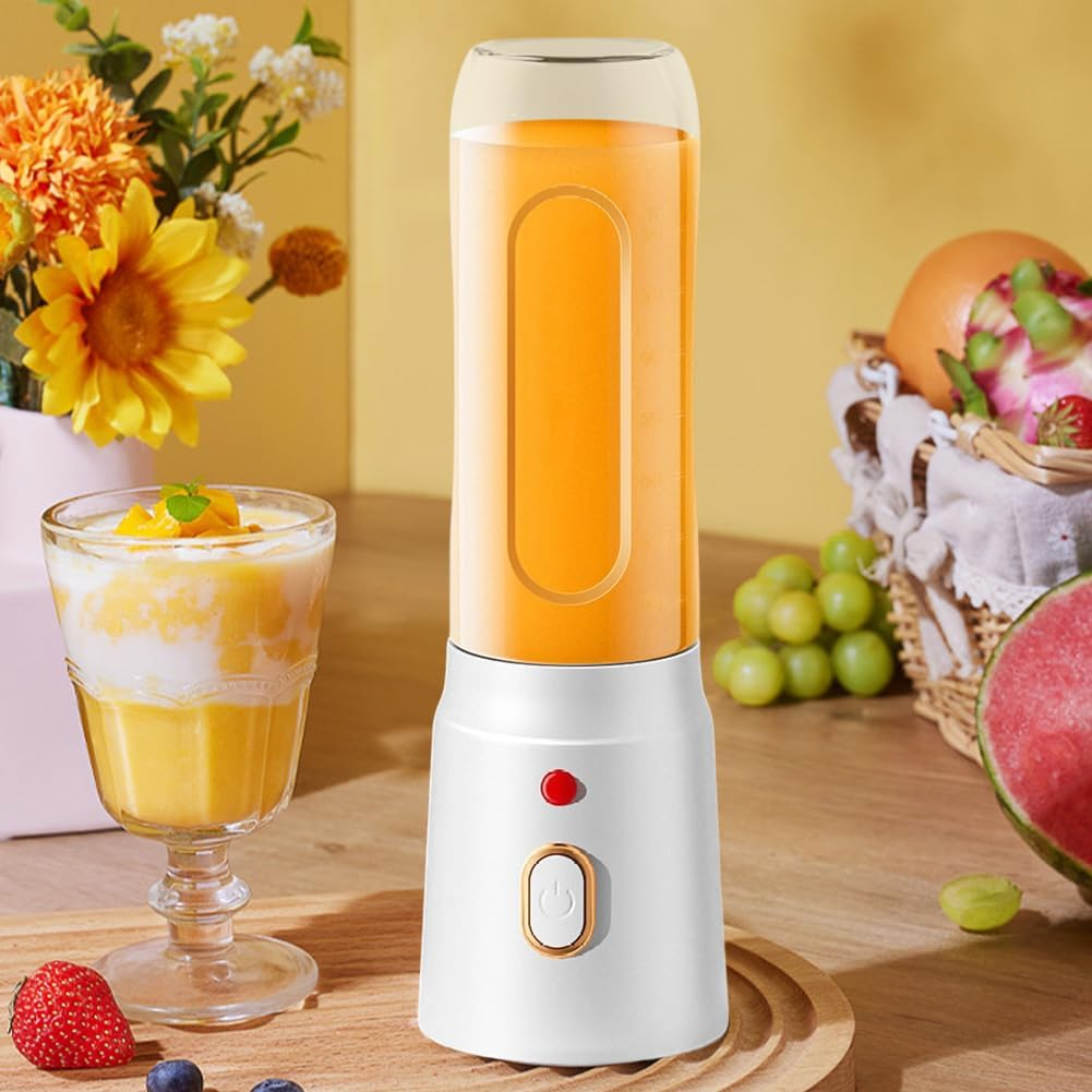 Ein tragbarer Mixer mit Orangesaft steht neben einem Glas Smoothie und Früchten.