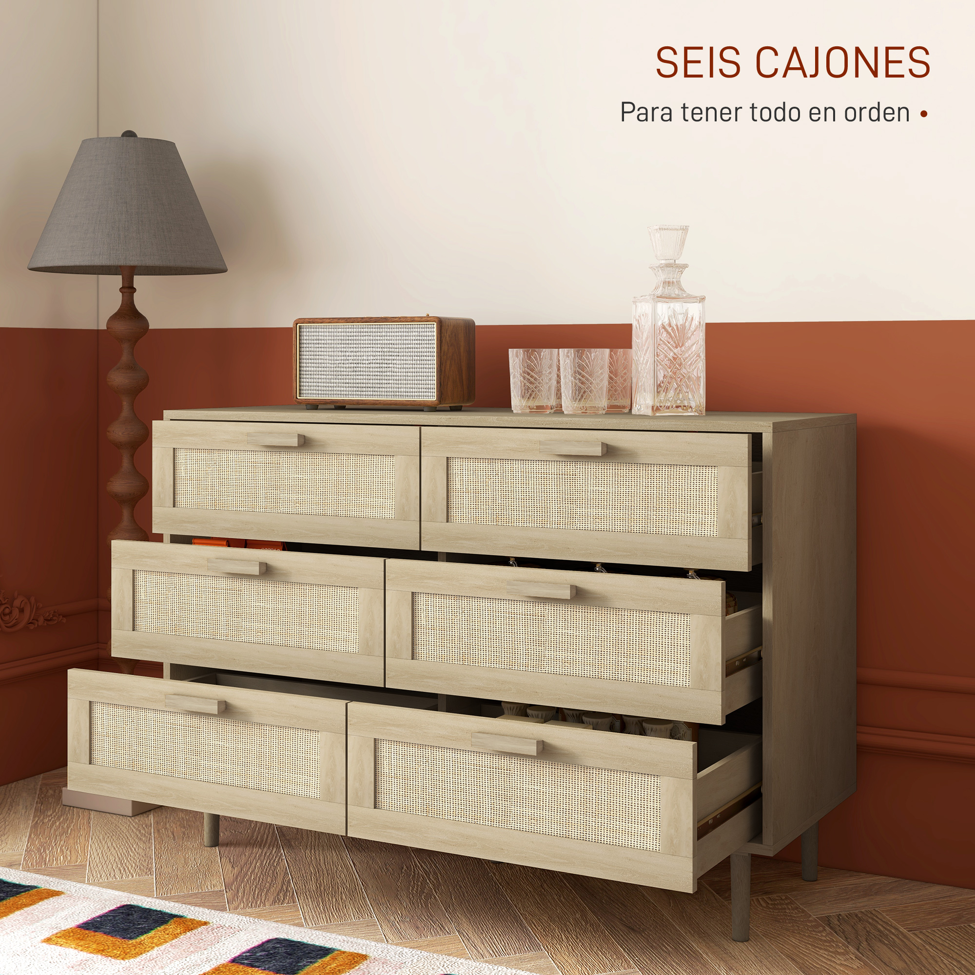 Cómoda de madera con seis cajones de ratán, lámpara y vasos al lado.