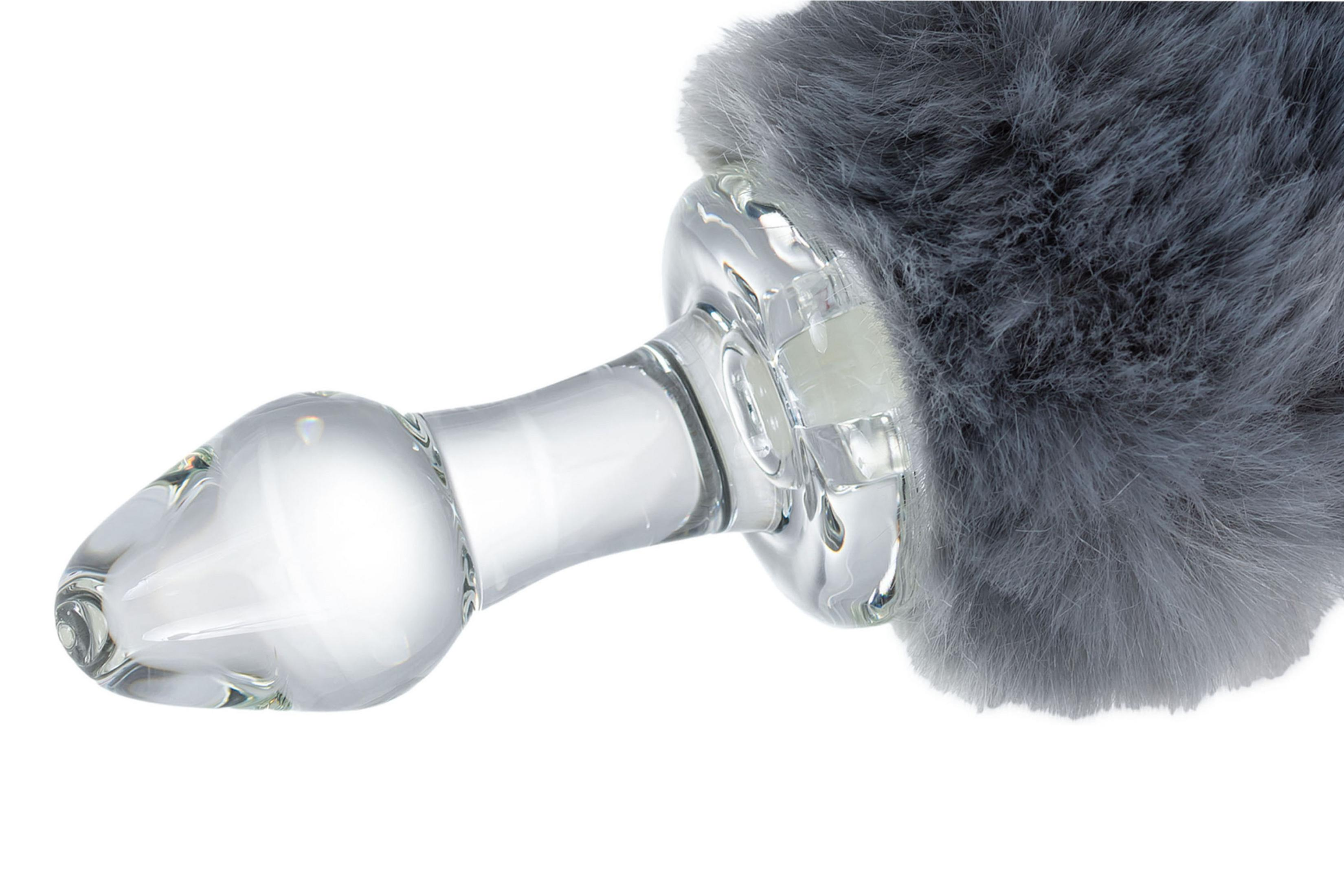 Ein durchsichtiger Glas-Buttplug mit grauem Kunstfell am Ende.