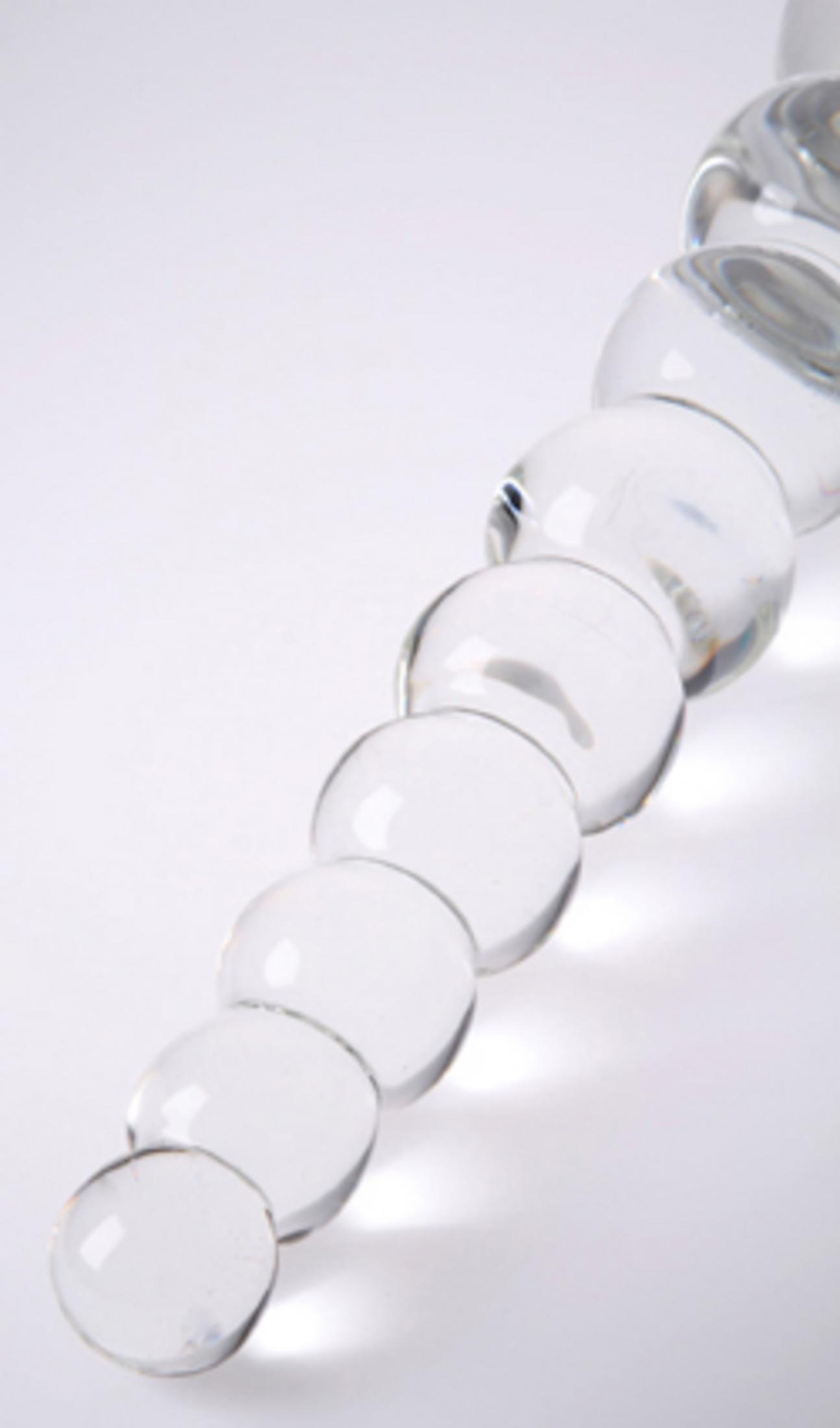 Eine Reihe von durchsichtigen Glaskugeln, die auf einer weißen Fläche angeordnet sind.