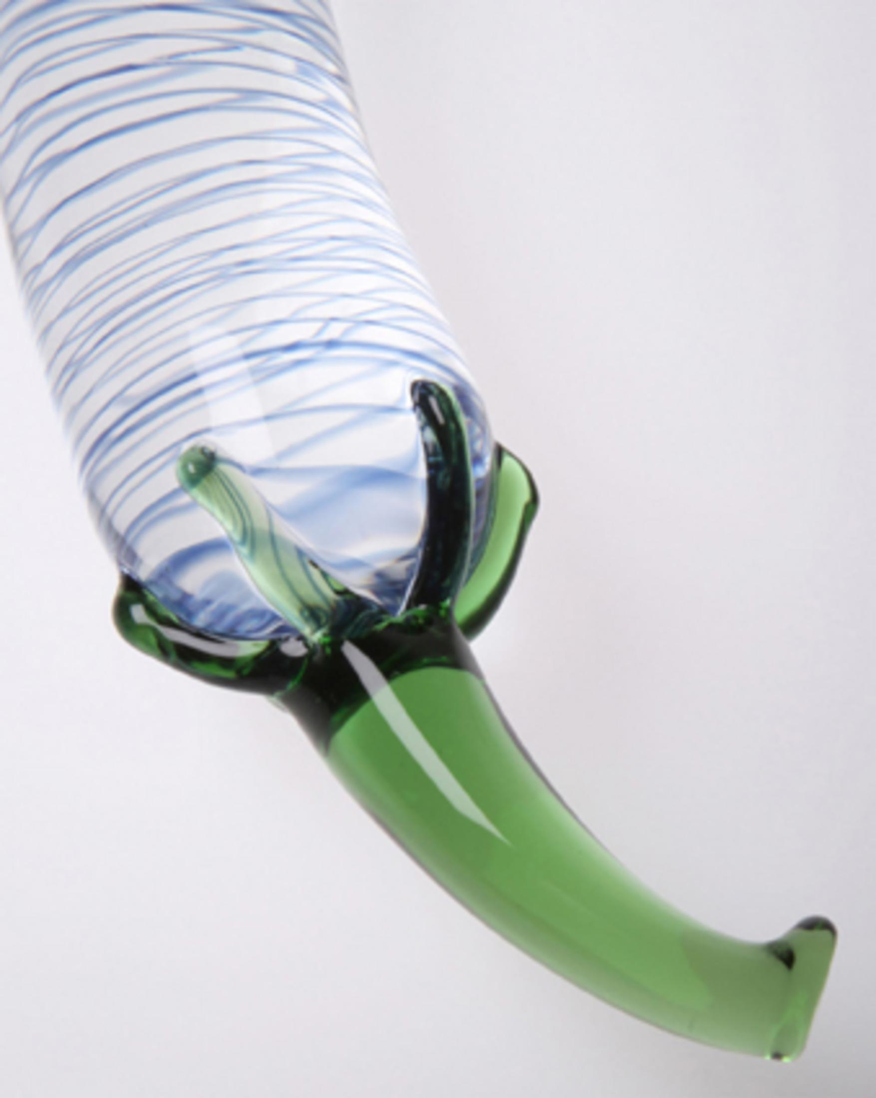 Ein grüner Glasfuß stützt einen transparenten Körper mit blauen Spiralen.
